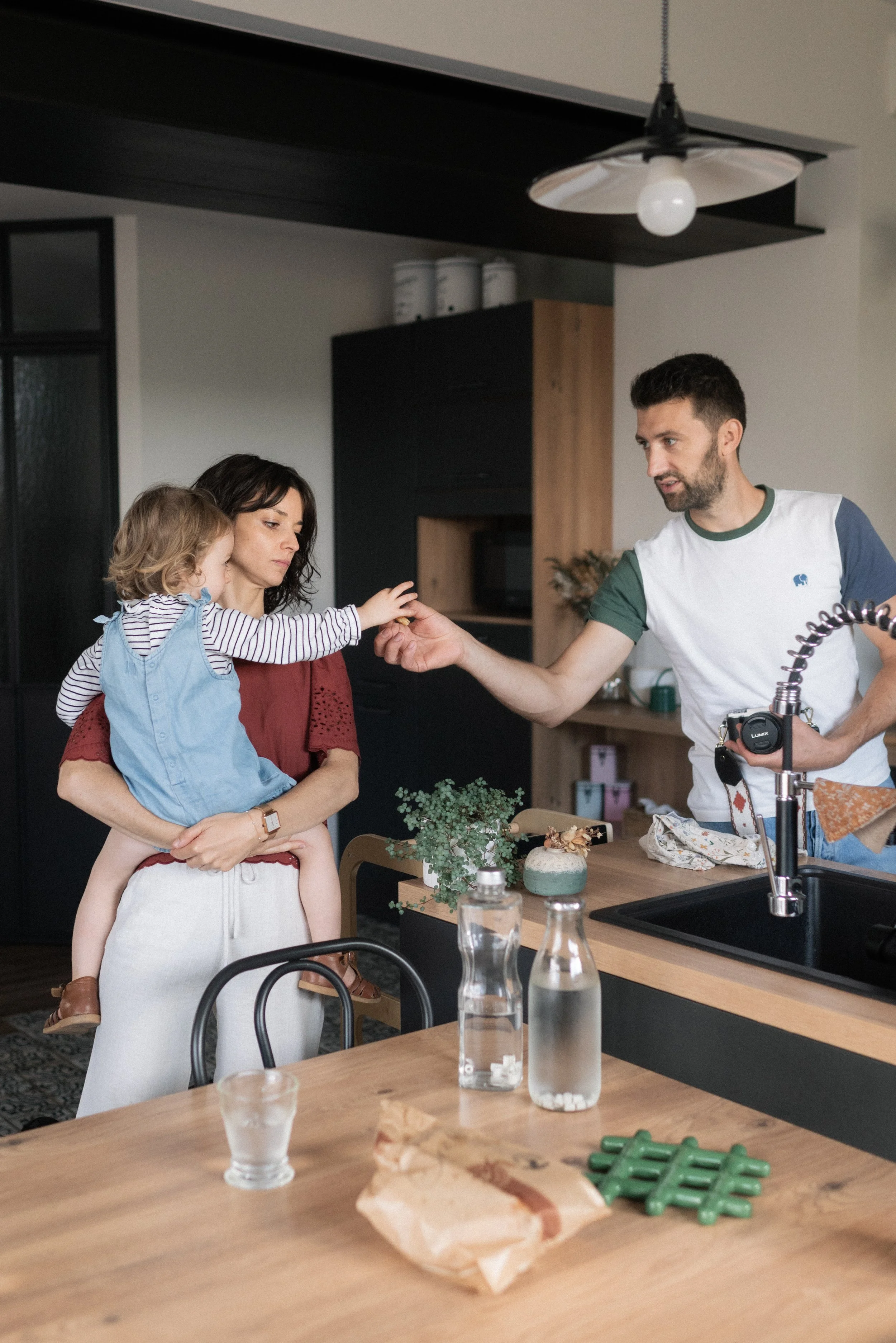 des parents et leur enfant dans leur cuisine