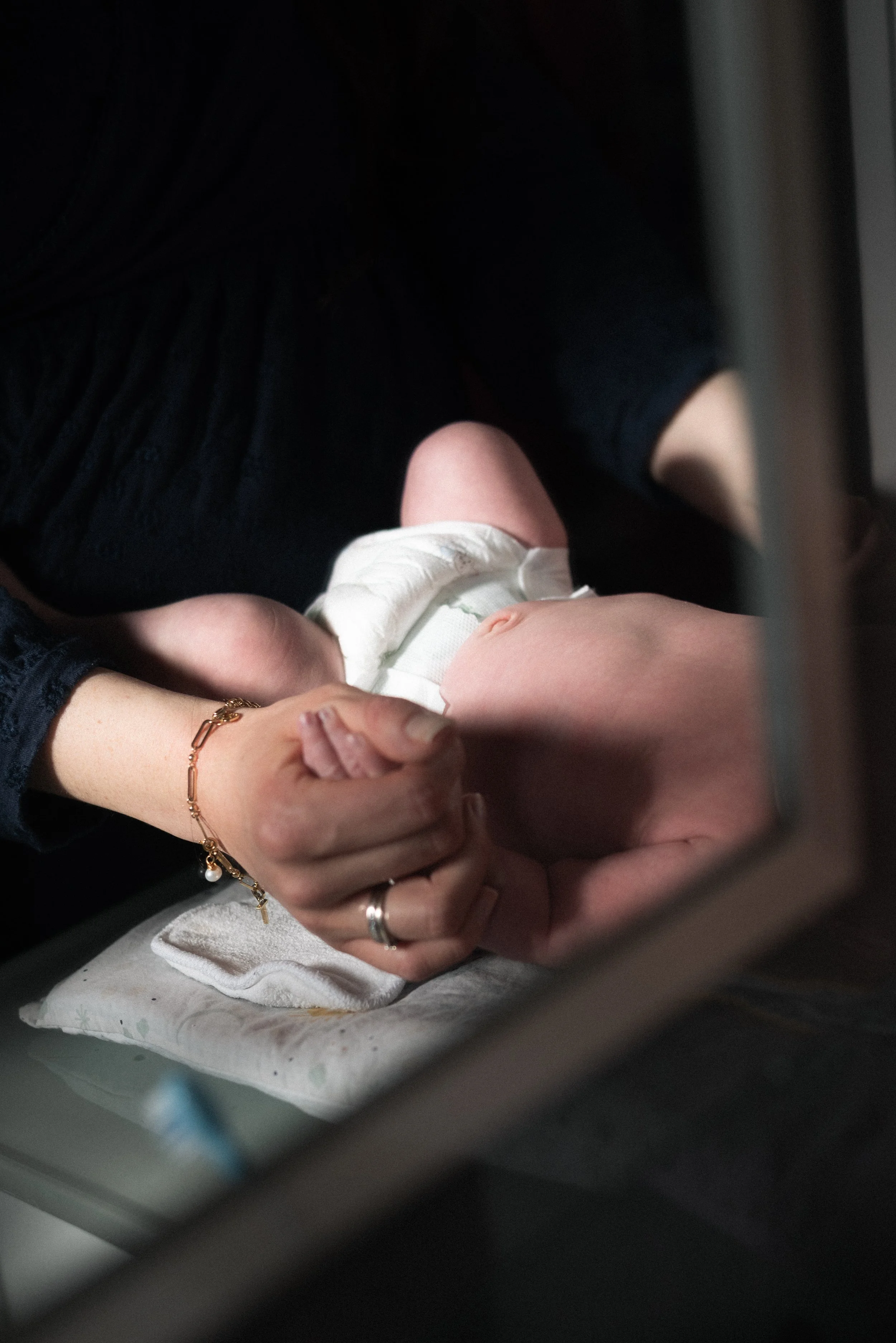 le reflet dans le miroir d'un bébé en couche et sa maman lui tiens la main dans la salle de bain à Ancenis