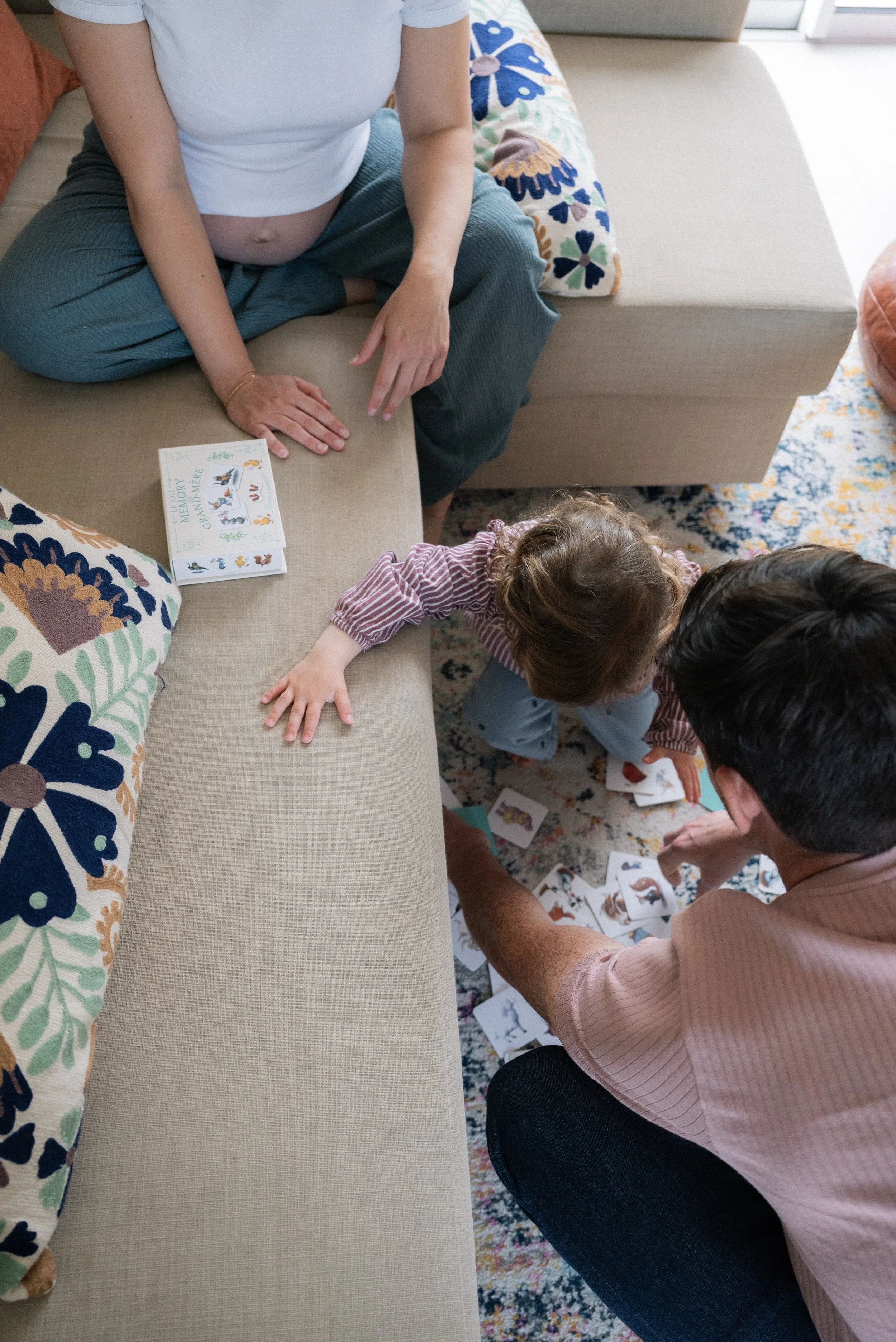 une enfant jouant aux cartes avec ses parents