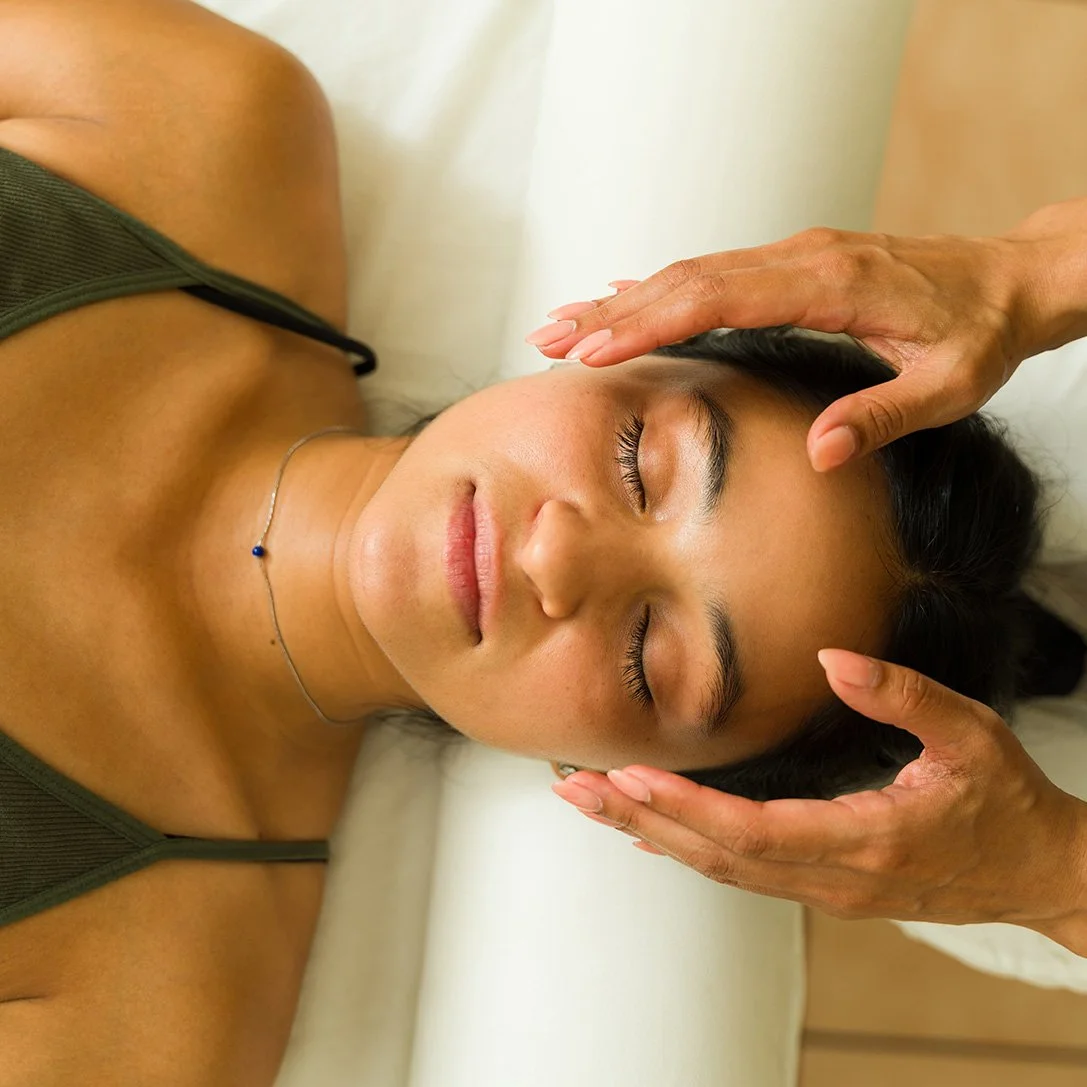 A white water lily with yellow center floating on dark water, with a bee on the flower.