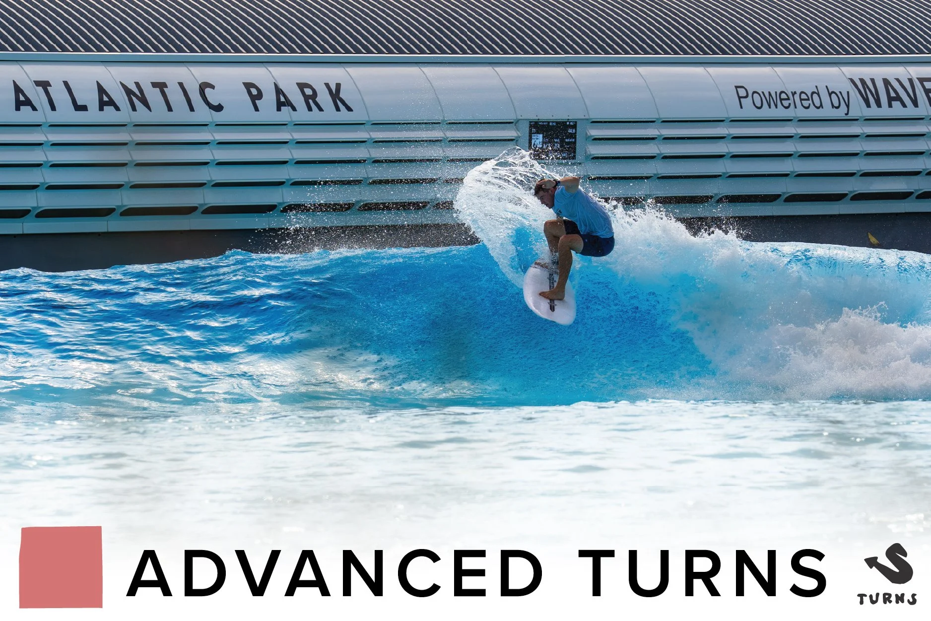 A surfer riding a wave at Atlantic Park with a modern building in the background.