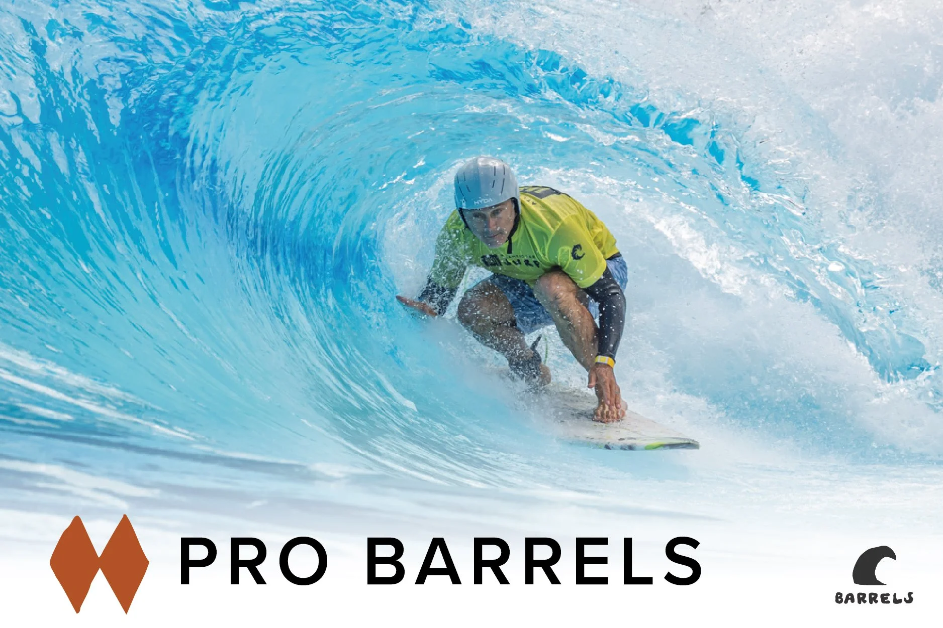 A man wearing a yellow shirt and helmet surfing inside a large blue wave.