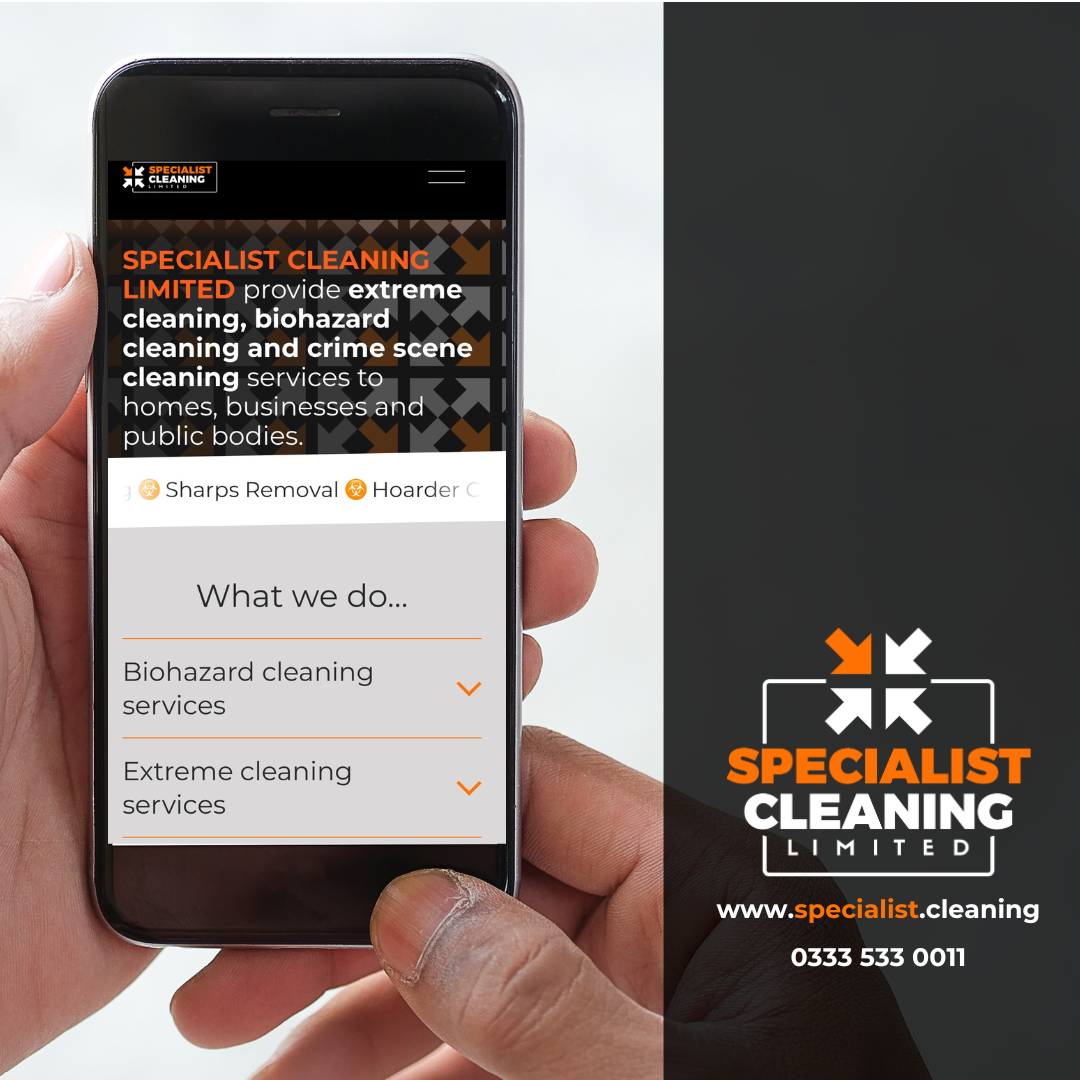 A person holding a smartphone displaying the website homepage of Specialist Cleaning Limited, which offers biohazard and extreme cleaning services. The webpage features a black, brown, and white patterned background with orange and white text, and a logo with an orange and black design.