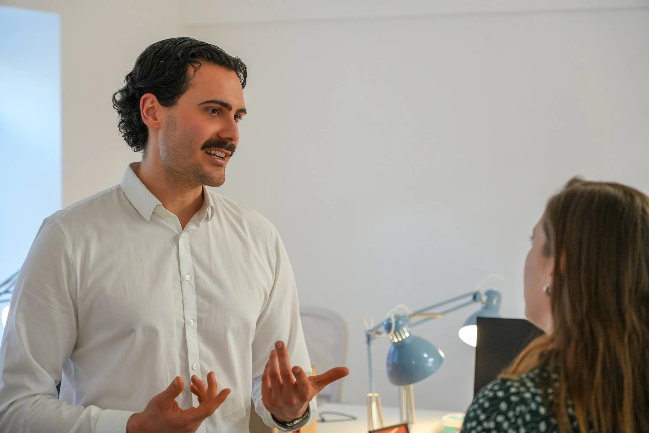 Marco Schmitt spricht in einem Büro mit einer Klientin