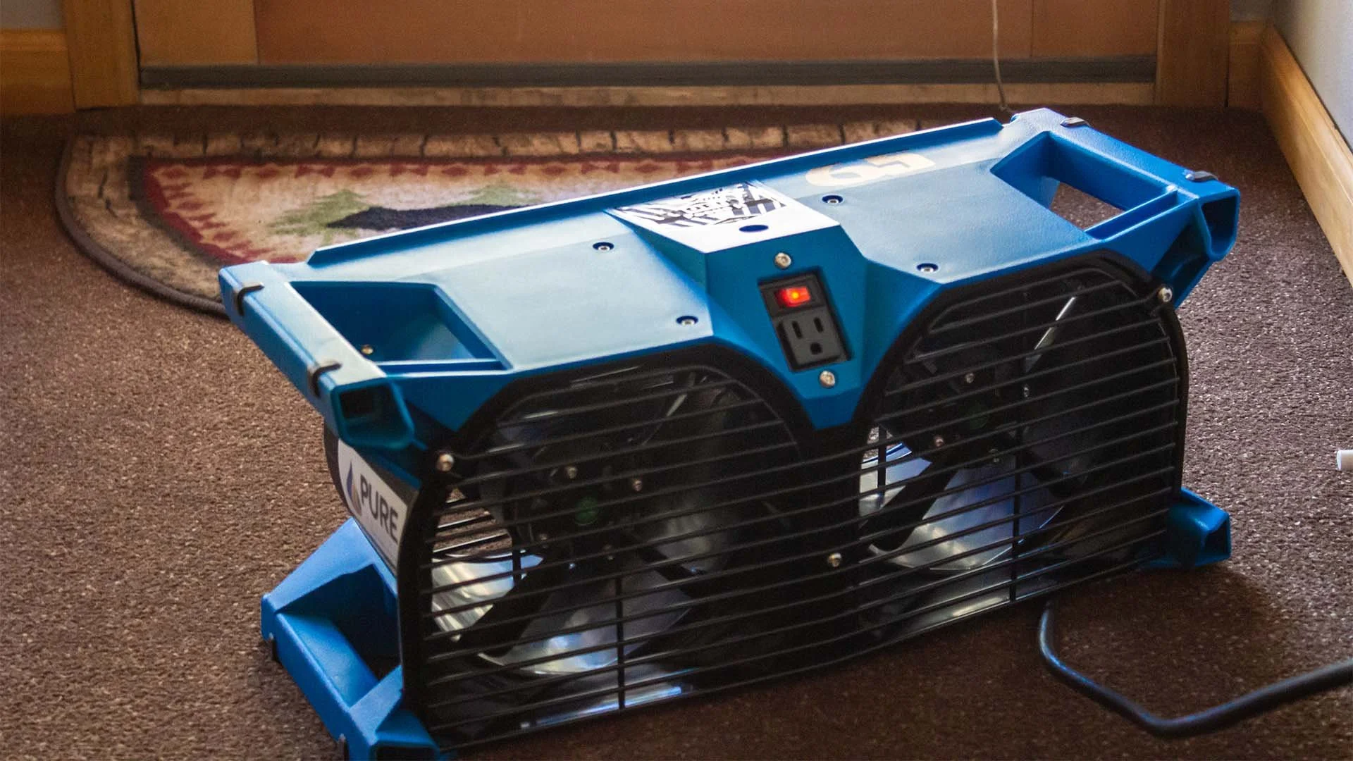 Dual axial fan close up. The device is placed on a wet rug.