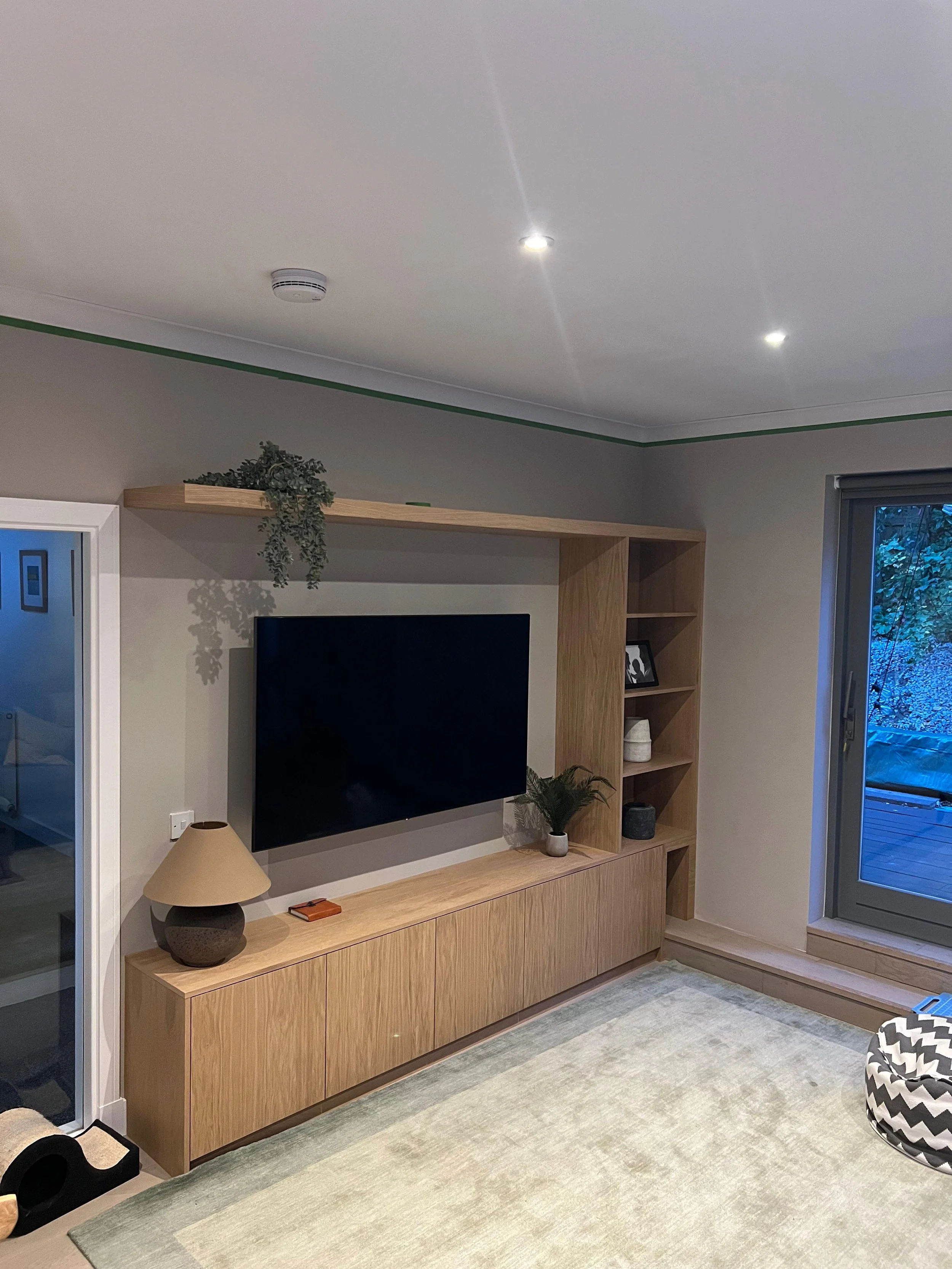 Bespoke oak veneered media wall with push to open doors and floating shelf