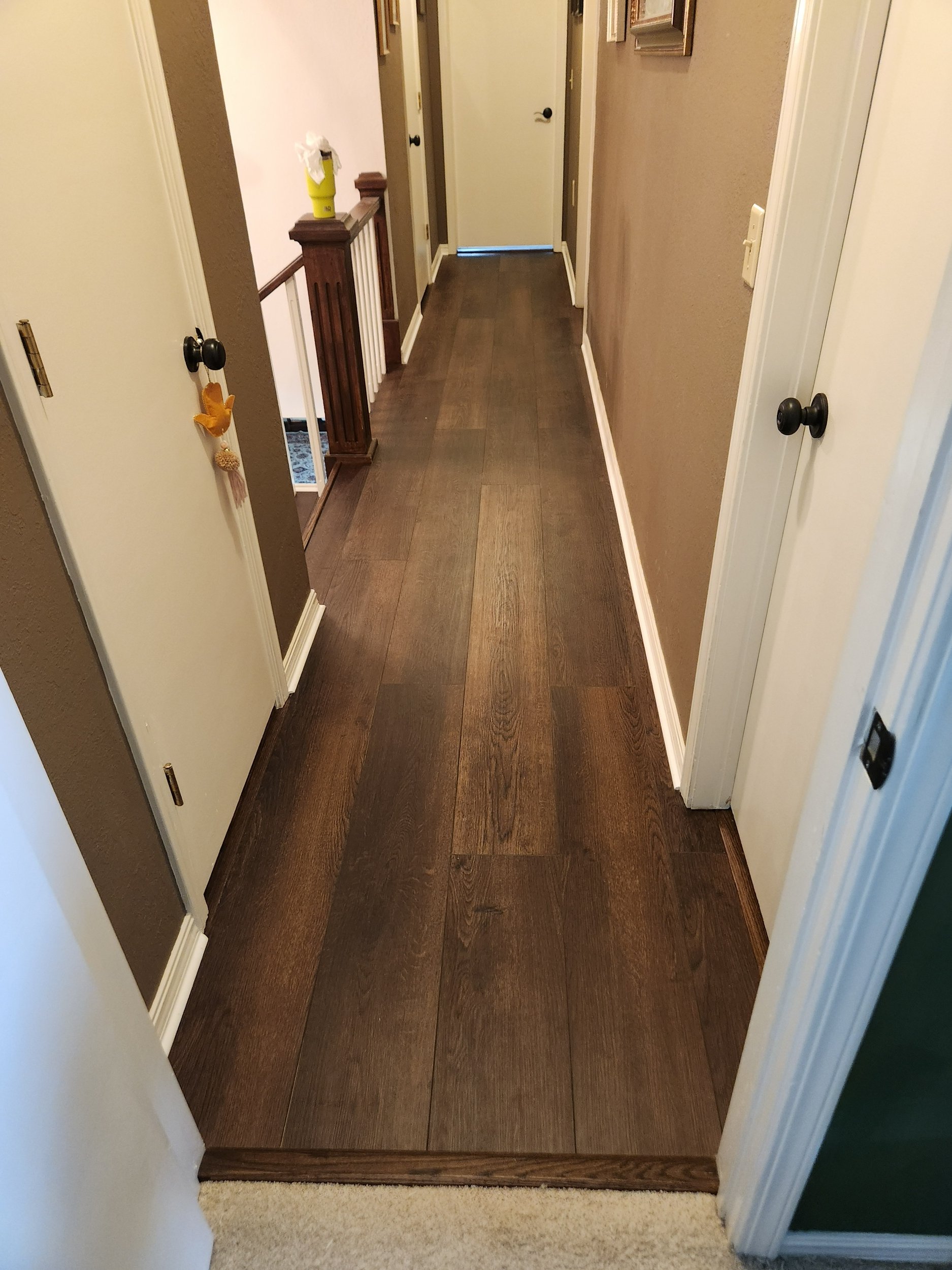 Hallway finished with luxury vinyl plank flooring and custom stained trim