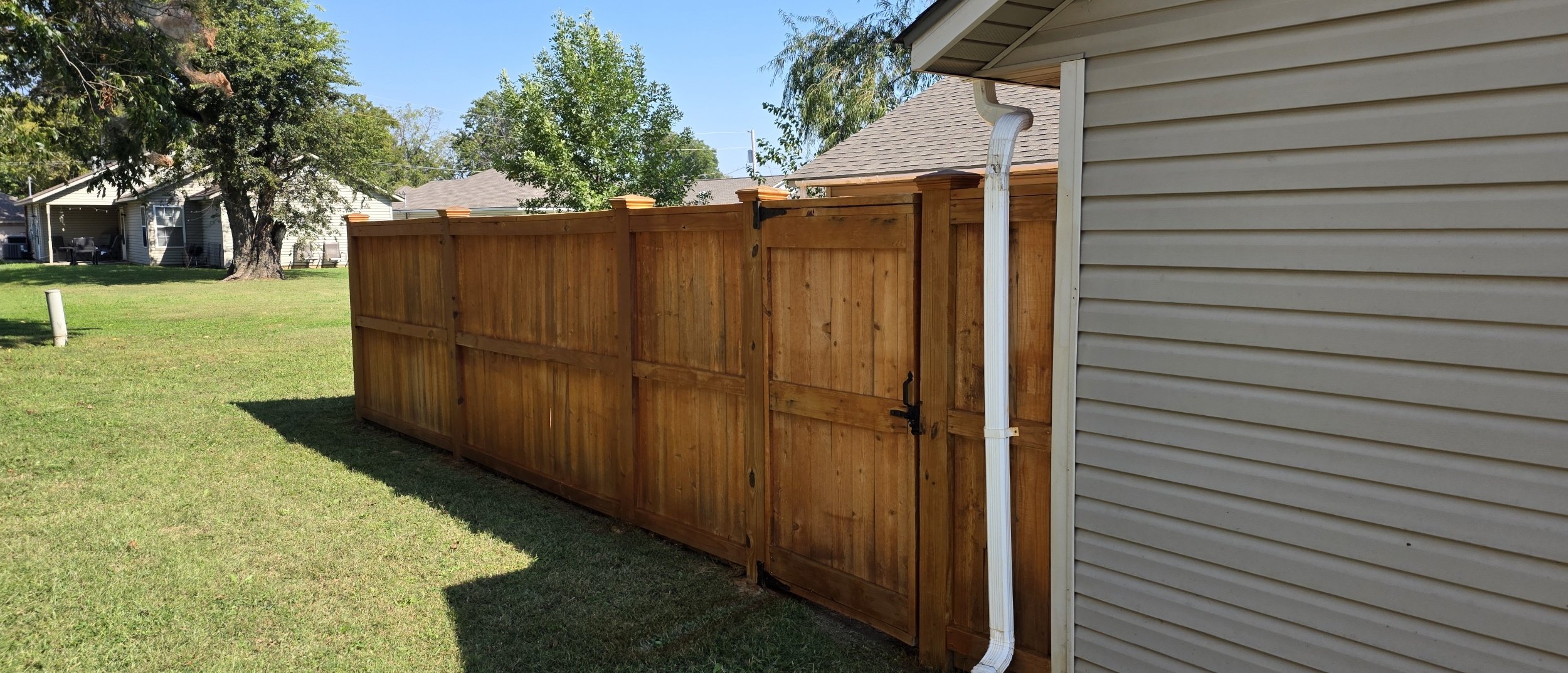 New wood privacy fence installed along the side of the home