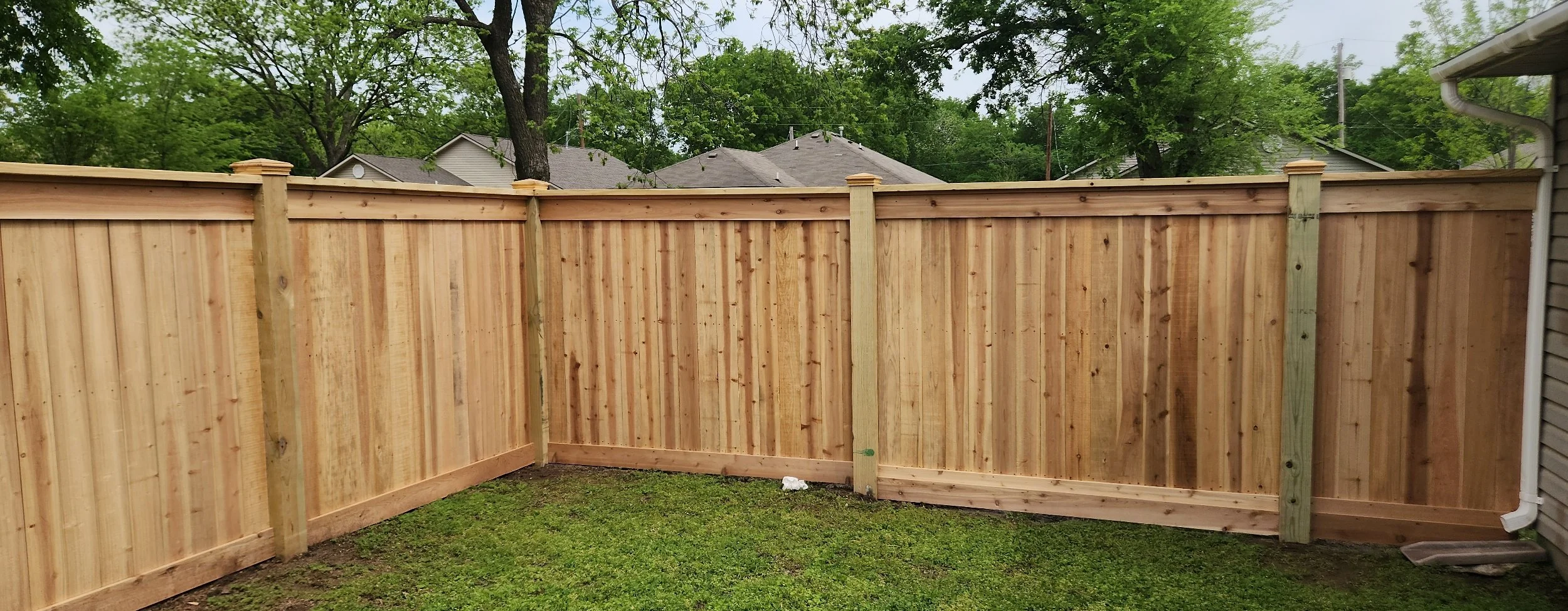 Completed wood privacy fence replacement with new posts and fence panels