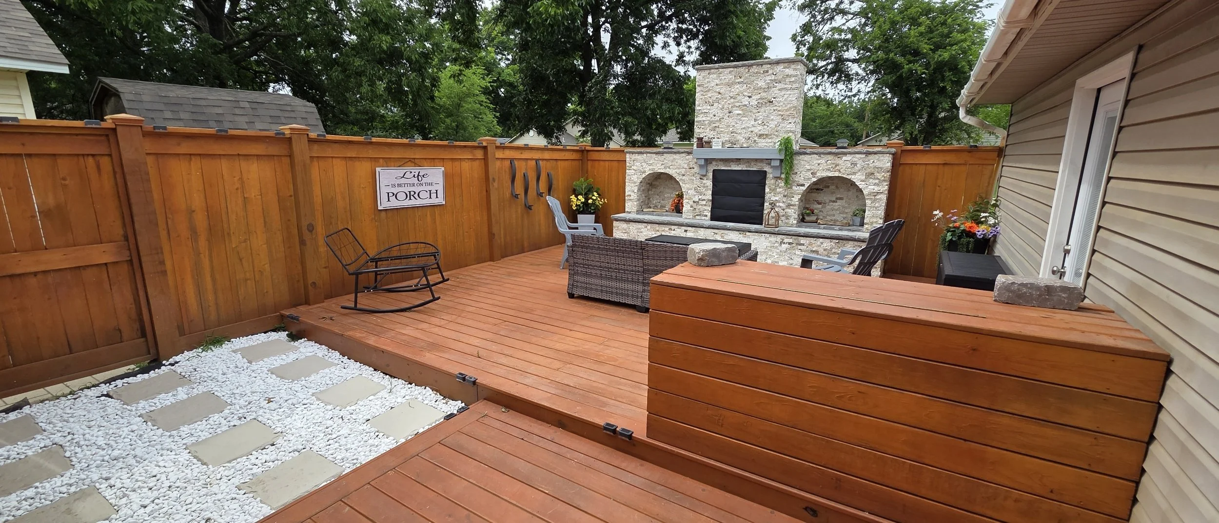 Finished outdoor living space with custom wood deck, privacy fence and built-in storage