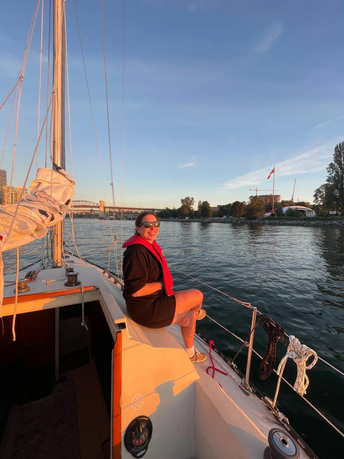 A smiling woman sailing at sunset