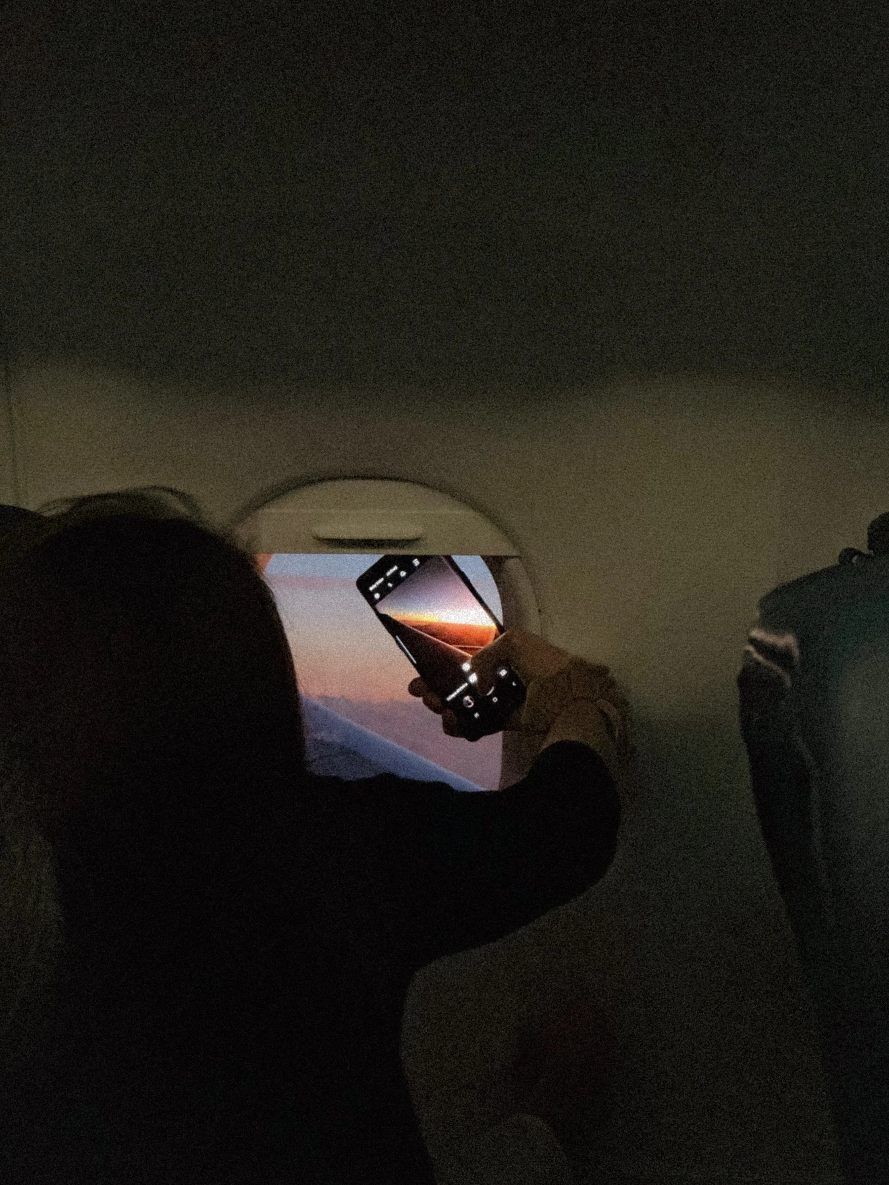woman taking a picture on plane