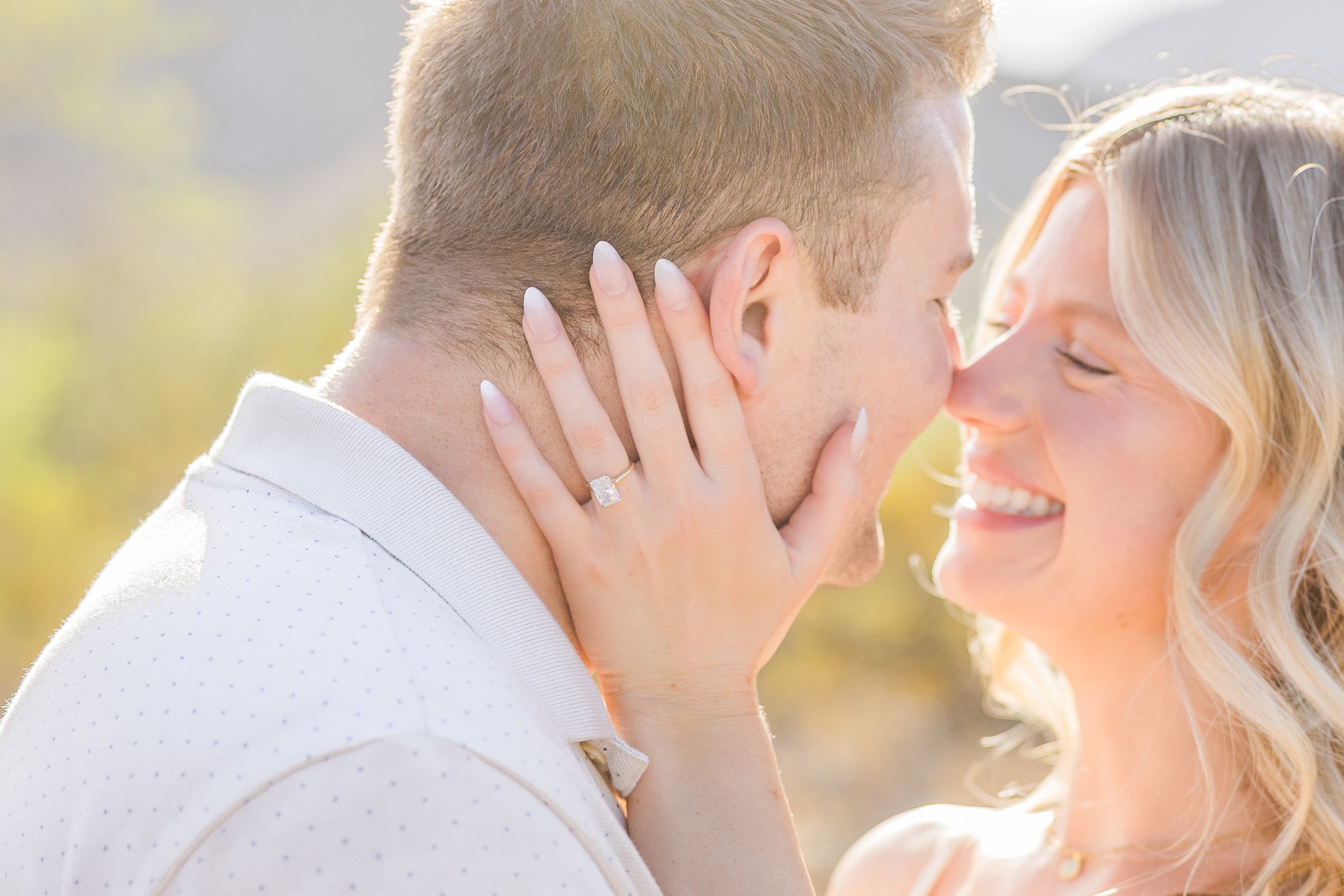 Close-up of a person wearing a ring with a large, clear gemstone, holding hands with another person.
