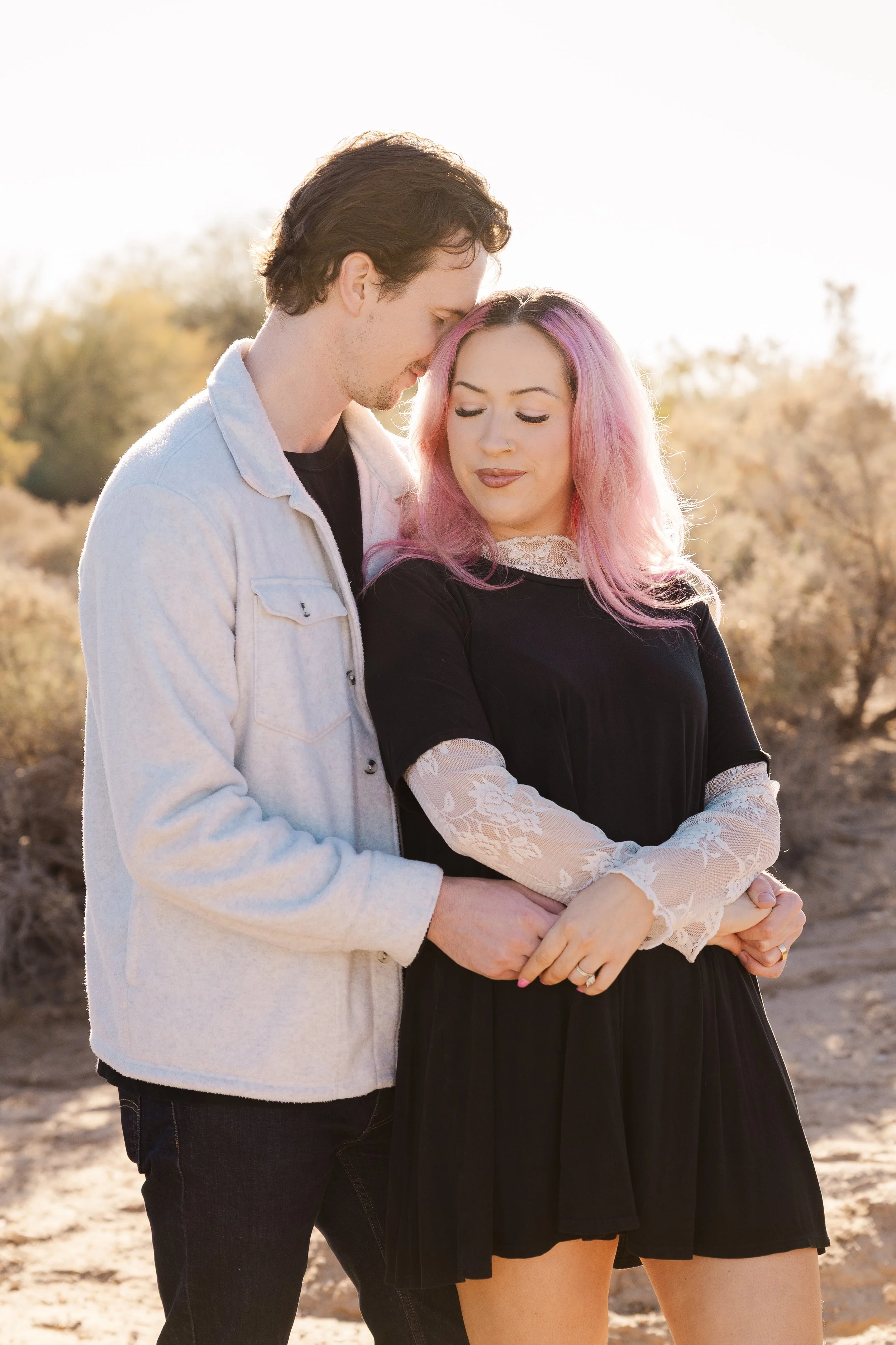 Close-up of a person wearing a ring with a large, clear gemstone, holding hands with another person.