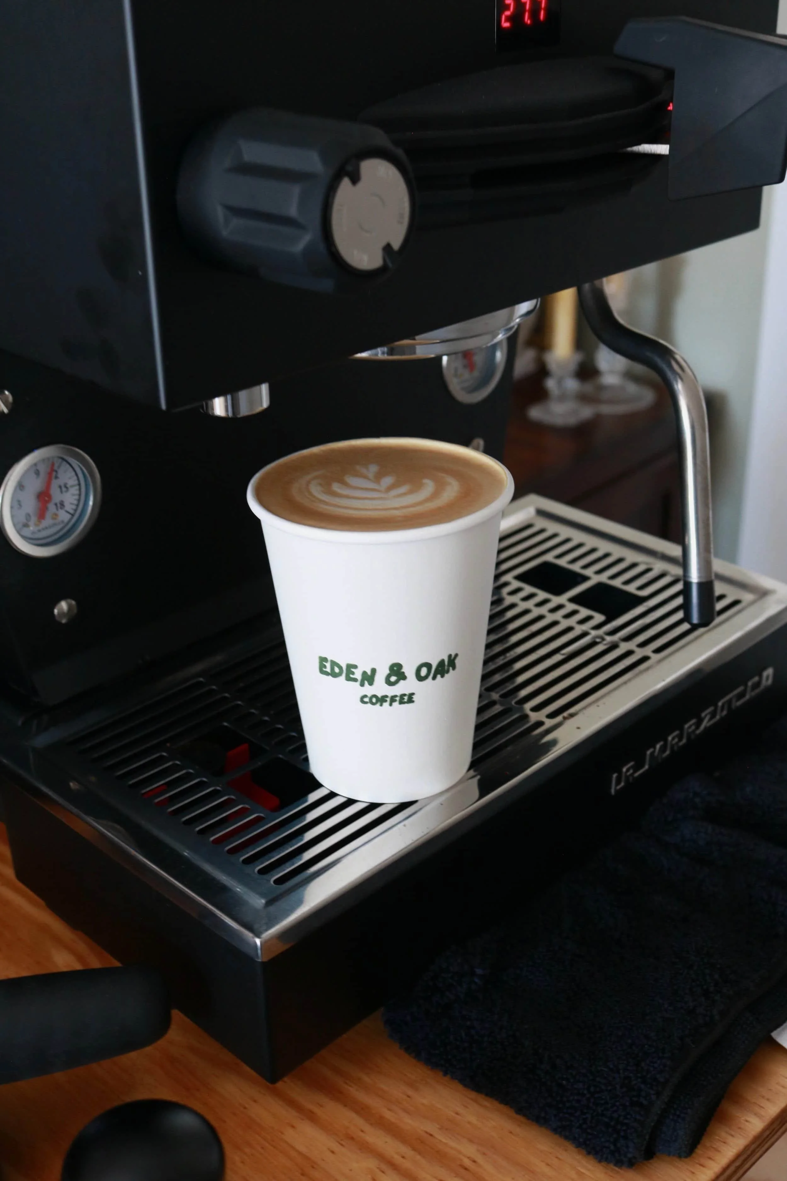 Eden & Oak Coffee Cup with custom latte art sitting on top of a La Marzocco Linea Mini Espresso Machine.