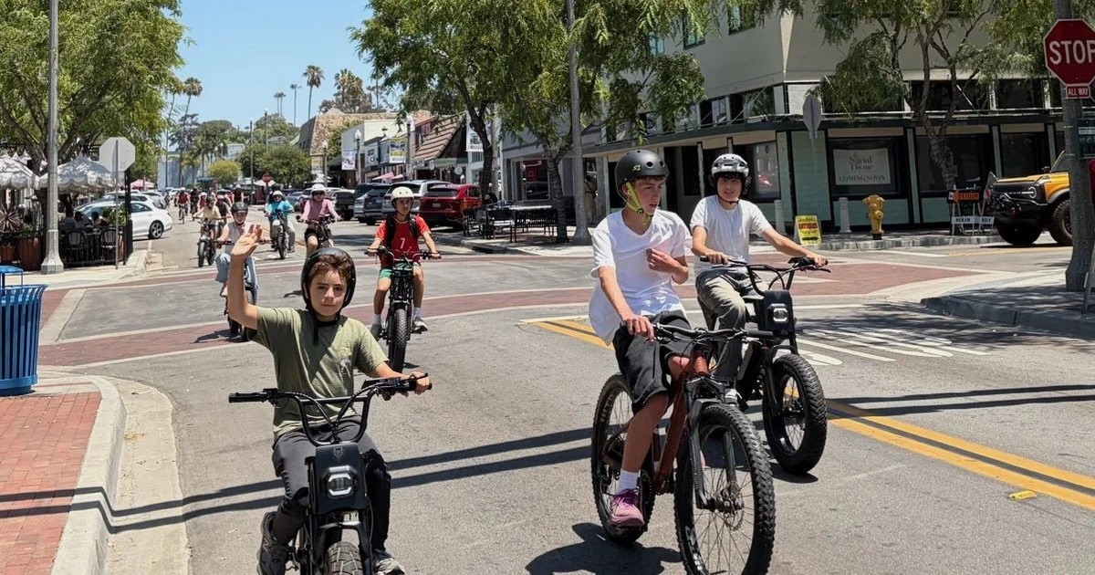 Kids and adults riding bikes down a La Mesa street during a City Cycling class