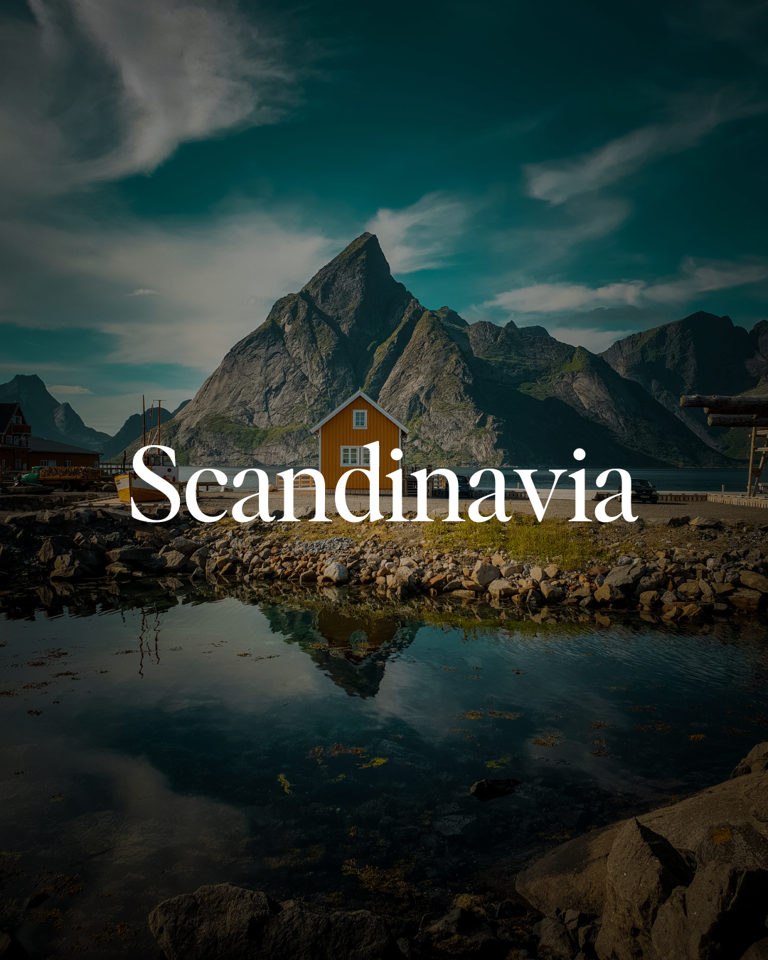 Scenic view of a yellow house near water with mountains in the background, under a partly cloudy sky, representing Scandinavia.