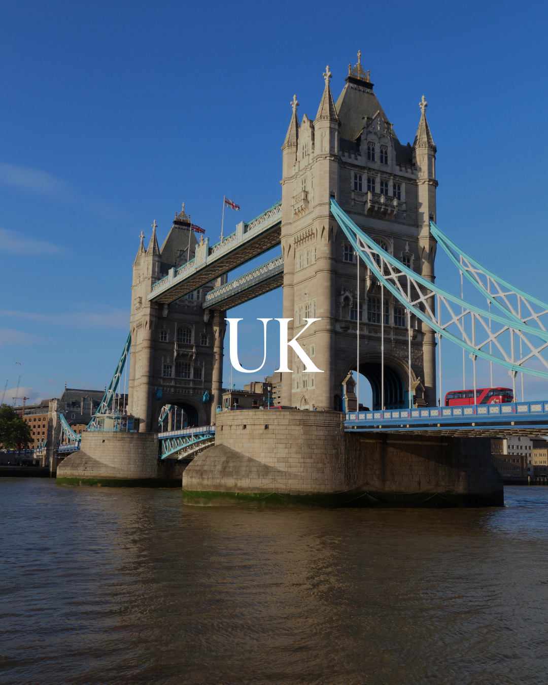 Tower Bridge crossing the River Thames in London, UK, with a red double-decker bus on the bridge.