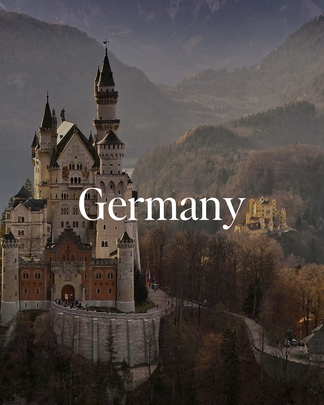 A castle with multiple towers situated on a hillside, with mountains and trees in the background, and the word 'Germany' written across the front.