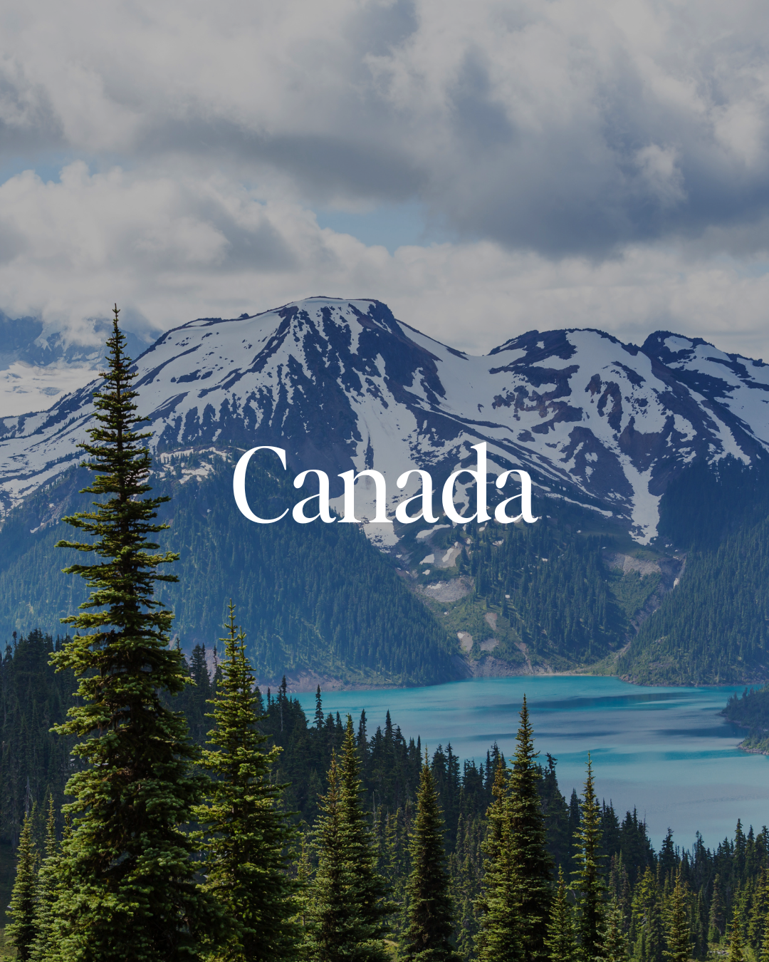 Scenic view of snow-capped mountains and evergreen trees with a turquoise lake in the foreground, labeled 'Canada'.