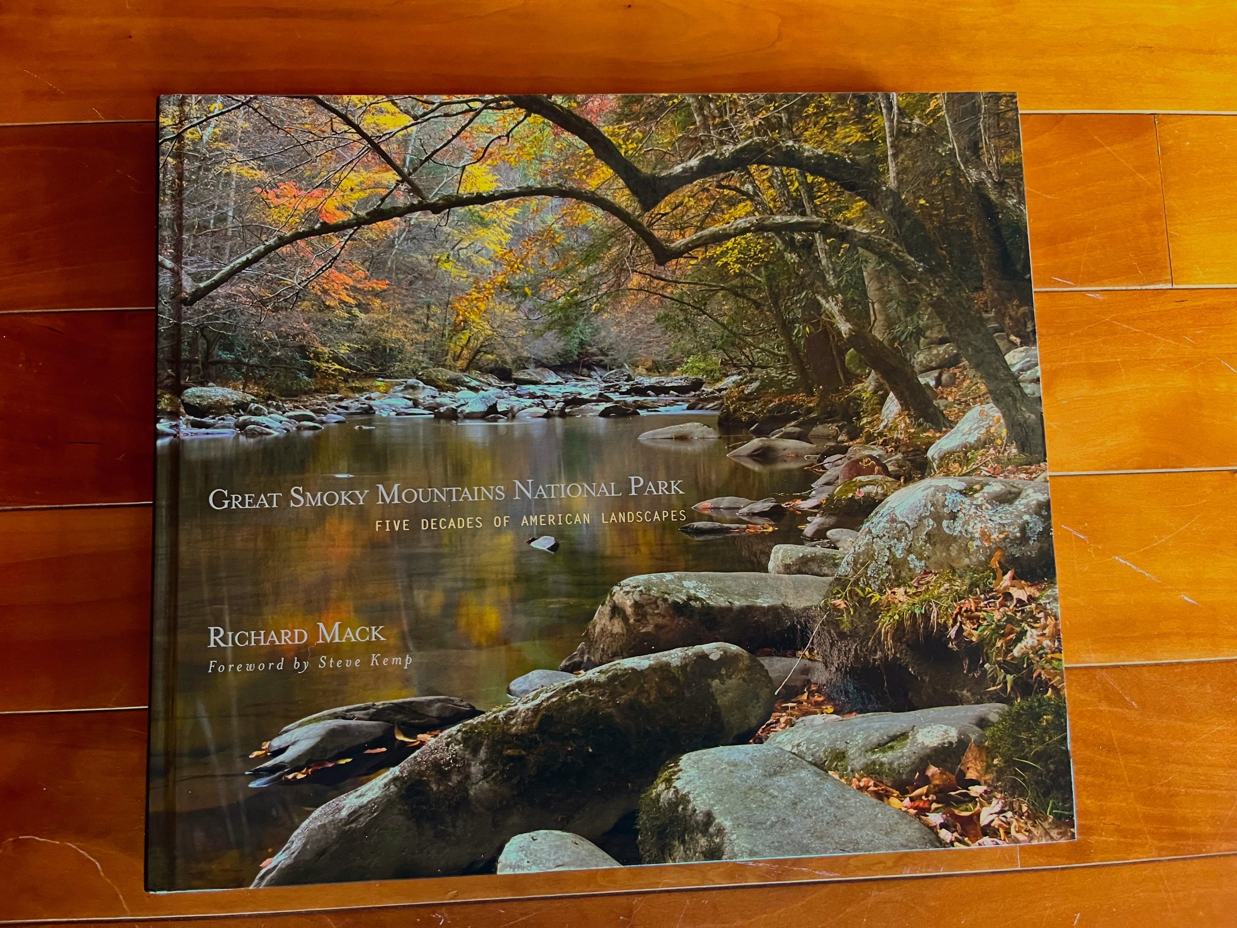 Book cover titled 'Great Smoky Mountains National Park: Five Decades of American Landscapes' by Richard Mack, featuring a river with rocks and colorful autumn trees.