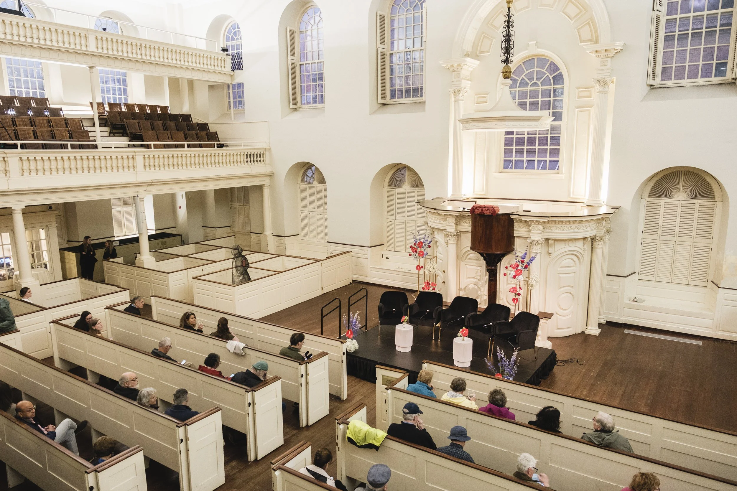  A church with small floral arrangements on the altar.  