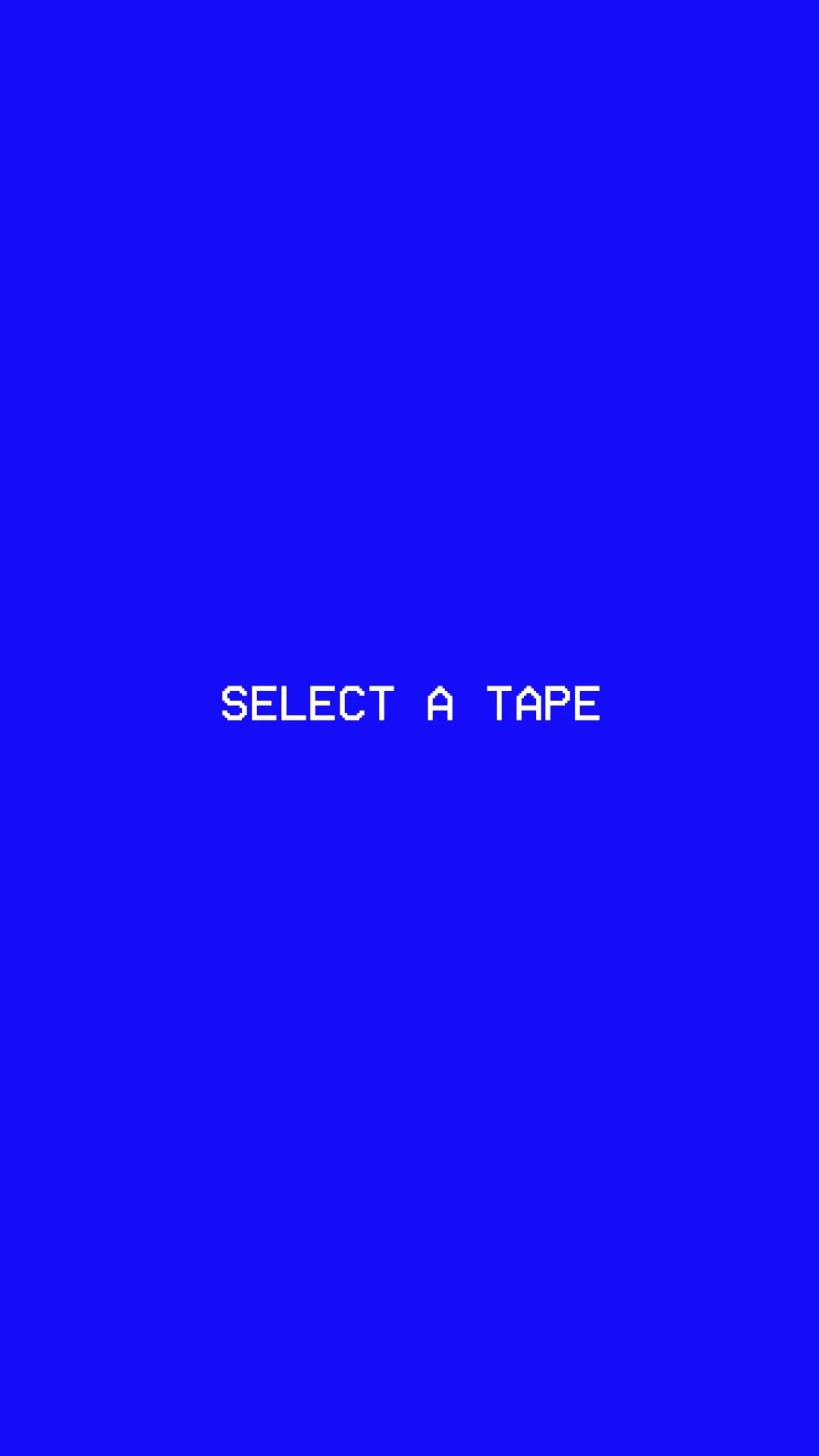 A blue screen with white text that says "SELECT A TAPE" and a smaller icon above that resembles a tape recorder or cassette tape.