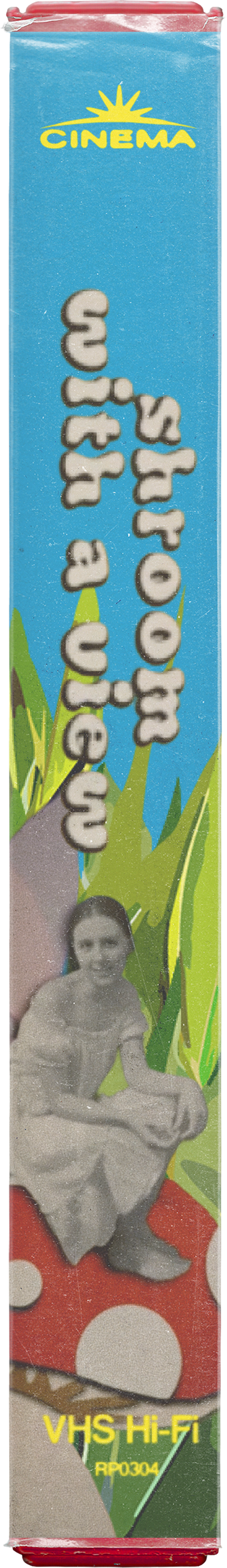 A VHS tape with a colorful label featuring the words "Shroom With A View" and an old black-and-white photo of a girl sitting on a red mushroom with white spots, green grass illustrated in the background, and the text "VHS Hi-Fi RP0304" in yellow.