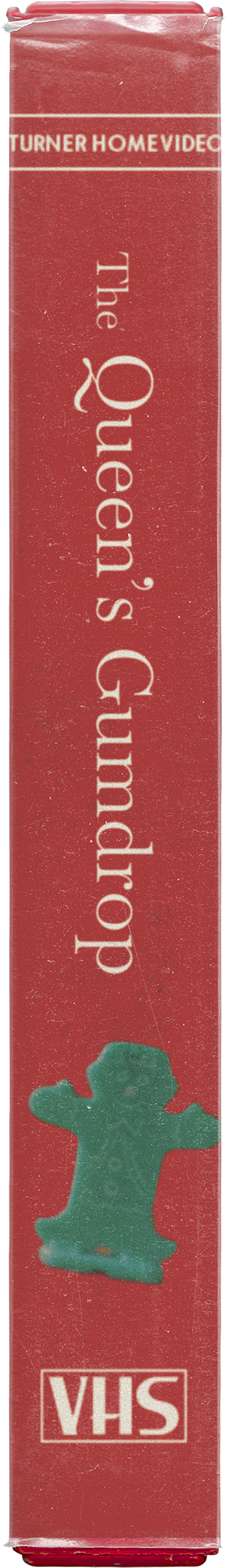 Close-up of a red VHS tape box for the movie 'The Queen's Gumdrop' by Turner Home Video, featuring a small green plastic game piece illustration.