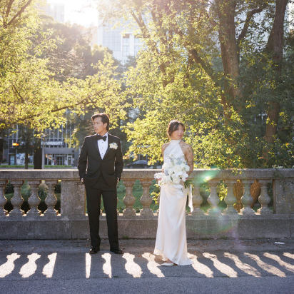 Couple dancing closely at a party, surrounded by other people on the dance floor with colorful lights and a checkered floor.