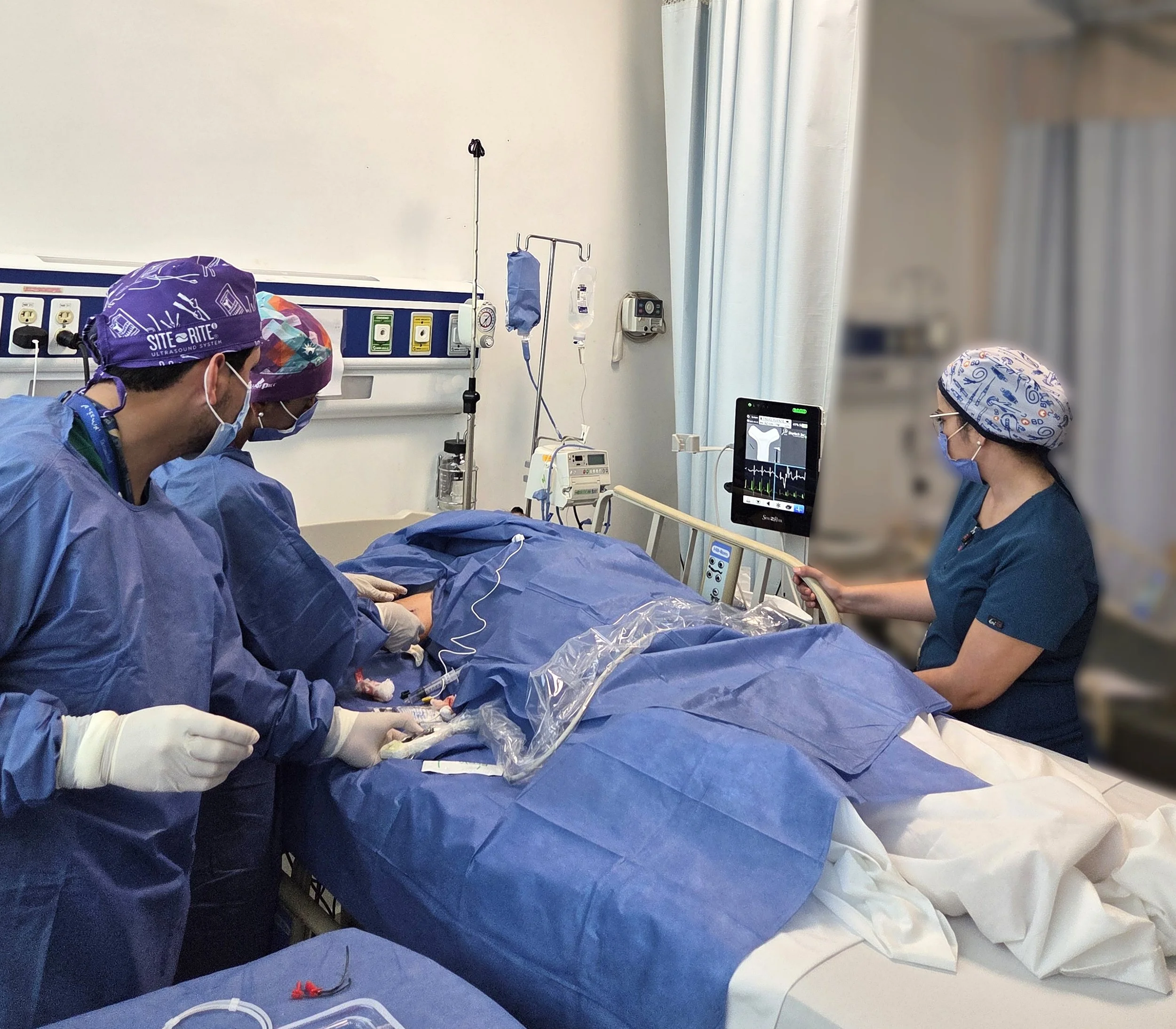 Equipo médico realizando una cirugía en un paciente en una sala de hospital, con monitores y equipo médico a su alrededor. ACÉRCATE Catéter PICC