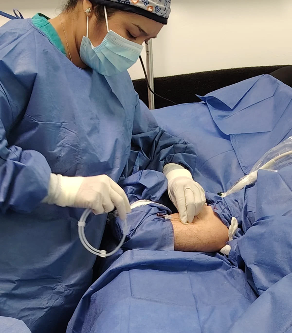 Una enfermera en equipo quirúrgico atendiendo a un paciente en una operación médica. ACÉRCATE Asociación para certificación y capacitación Técnica Catéter PICC