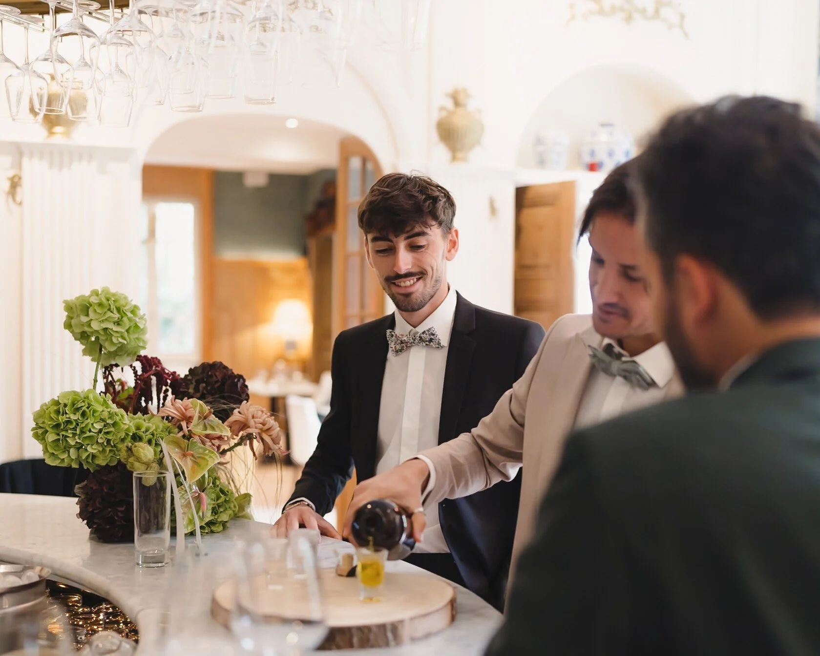 Instant de convivialité autour du bar, le marié et ses témoins dégustant un verre avant la cérémonie.
