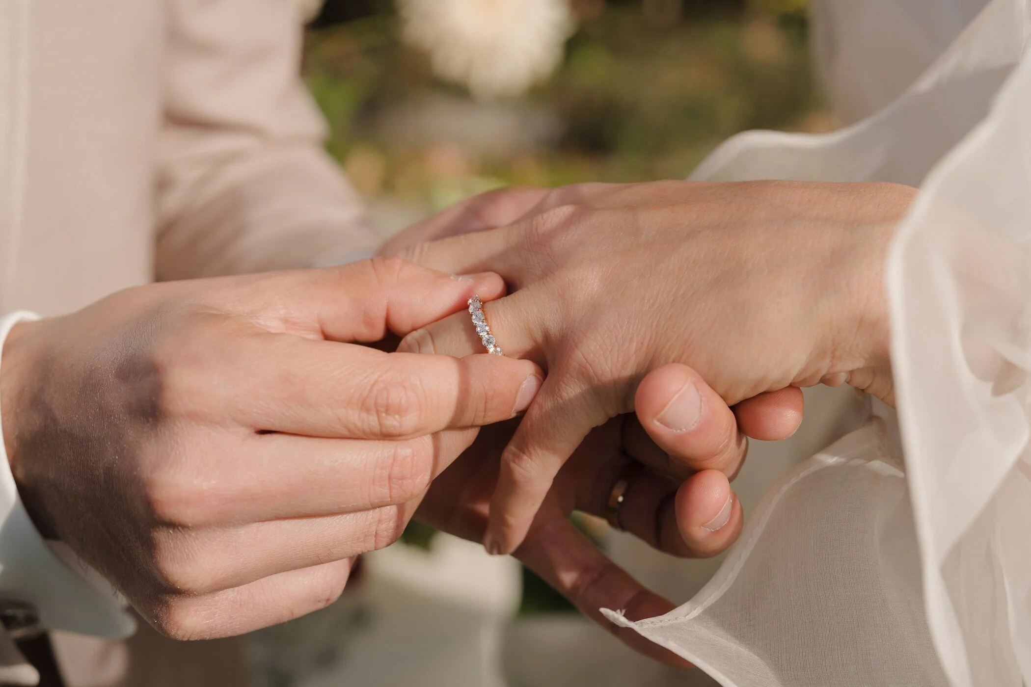 Gros plan sur la main de la mairée lors du passe des alliances.