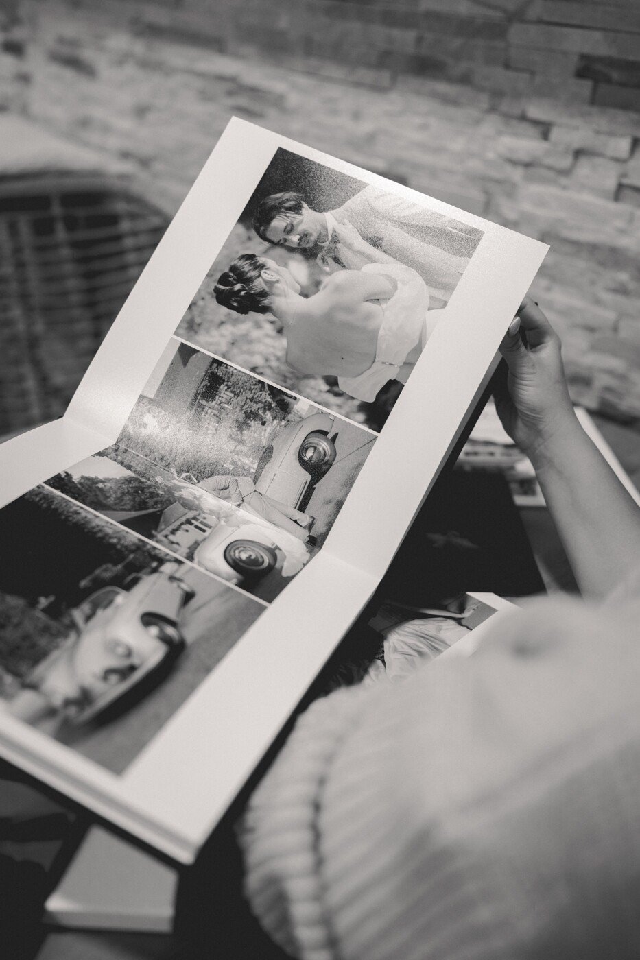 Une main feuillette un album de mariage, mettant en valeur des photos d'un reportage de mariage.