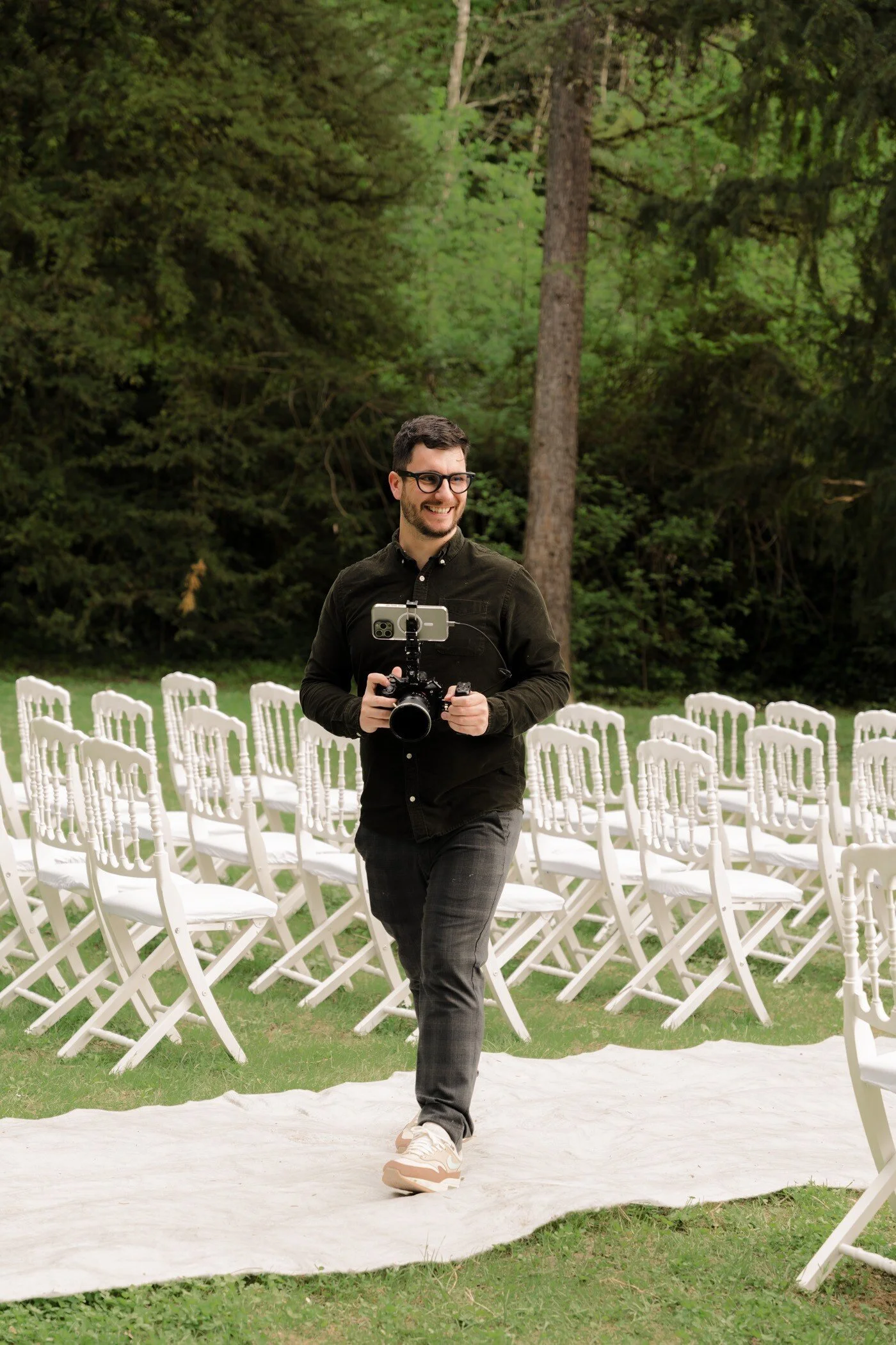 TAD, photographe dans une allée de cérémonie caméra à la main
