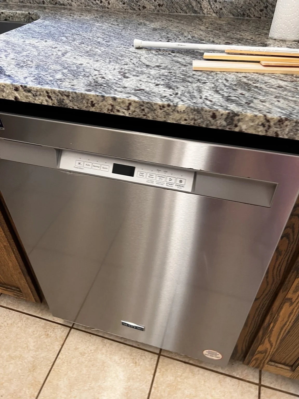 Clean stainless steel dishwasher and granite countertop after a residential cleaning.