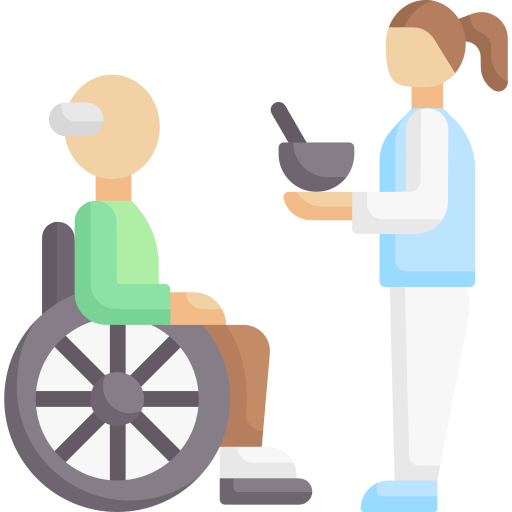 Medical professional with long hair in a bun wearing a light blue  coat feeding a patient in a wheelchair.