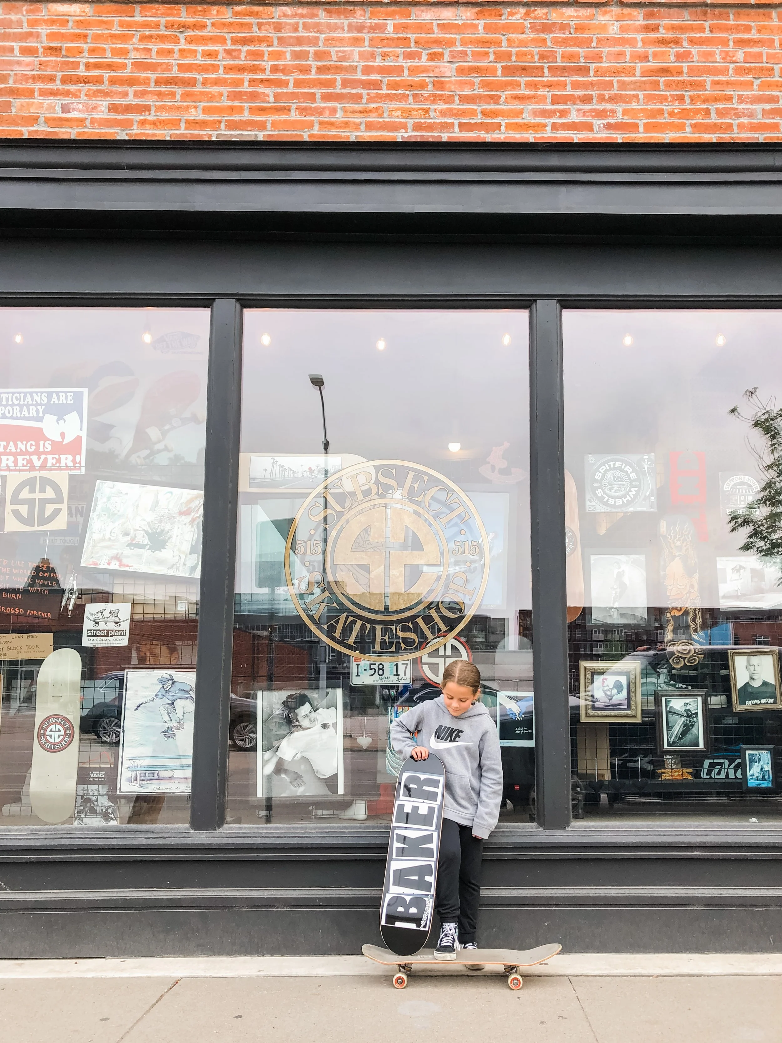  girl with skateboard outside Subsect skate shop 