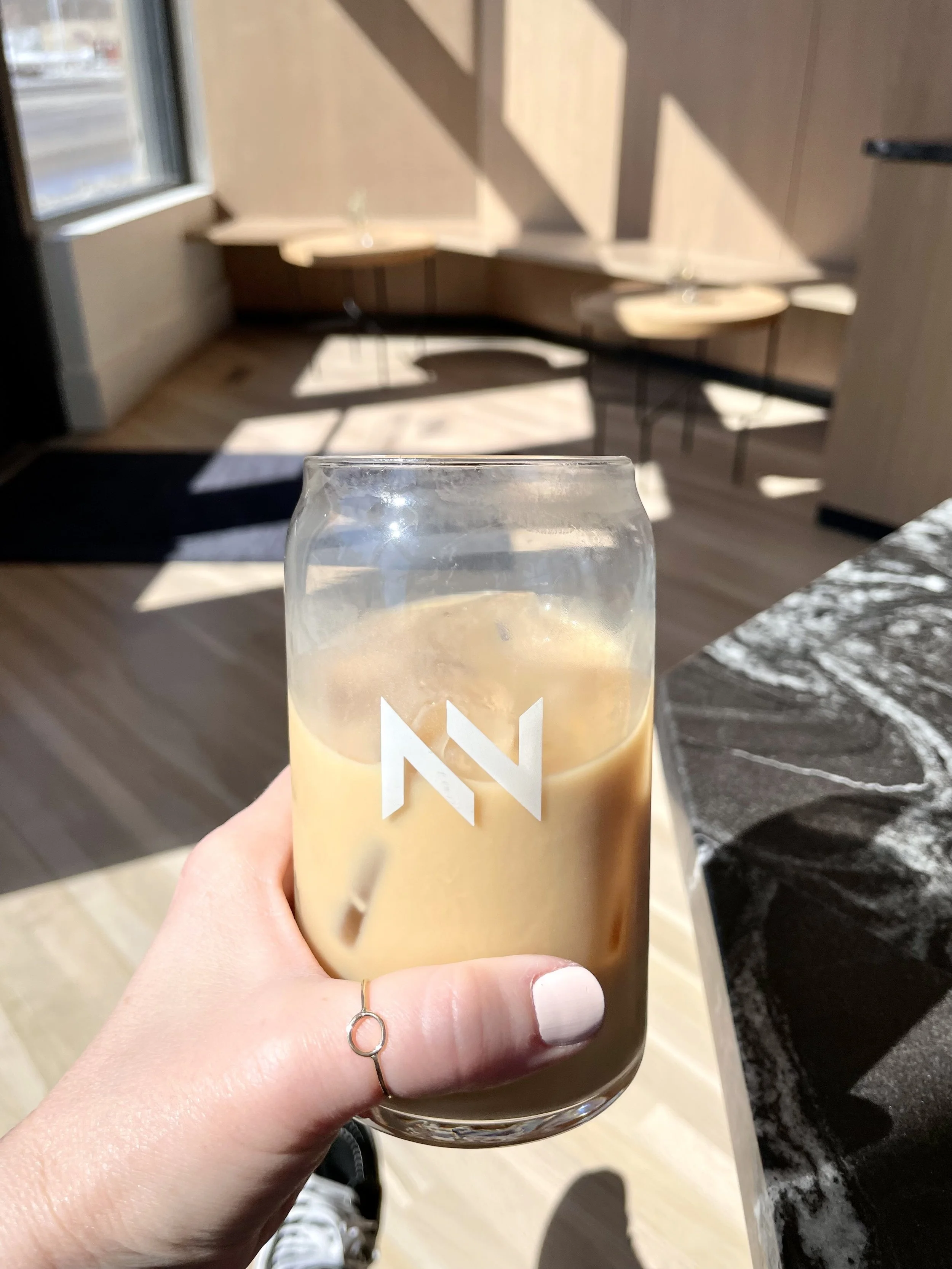 hand holding a glass of iced coffee at Northern Vessel