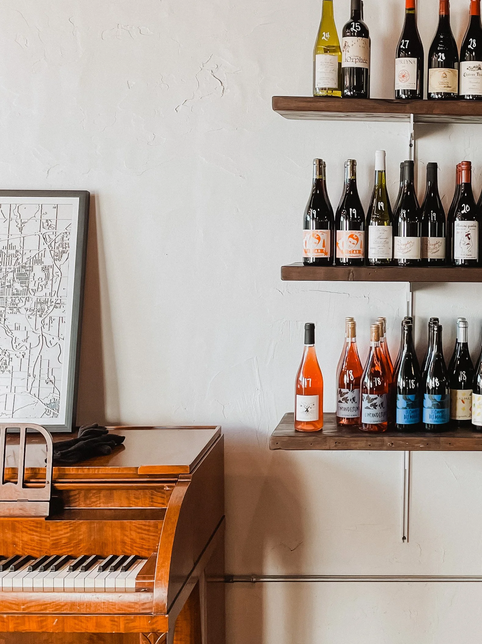 piano next to shelves of wine at The Cave