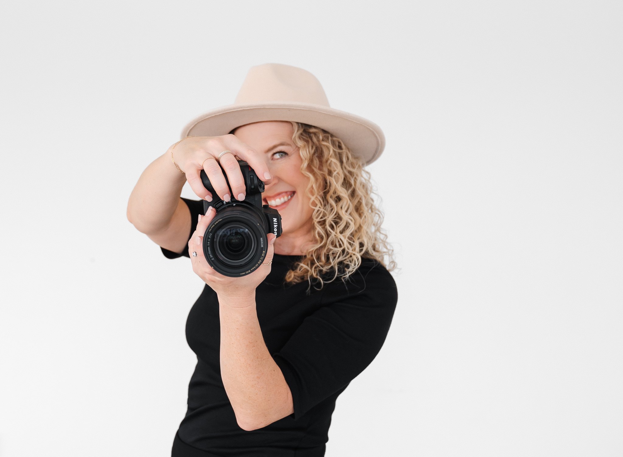 Jill Neil smiling from behind camera she's holding up in front of her face
