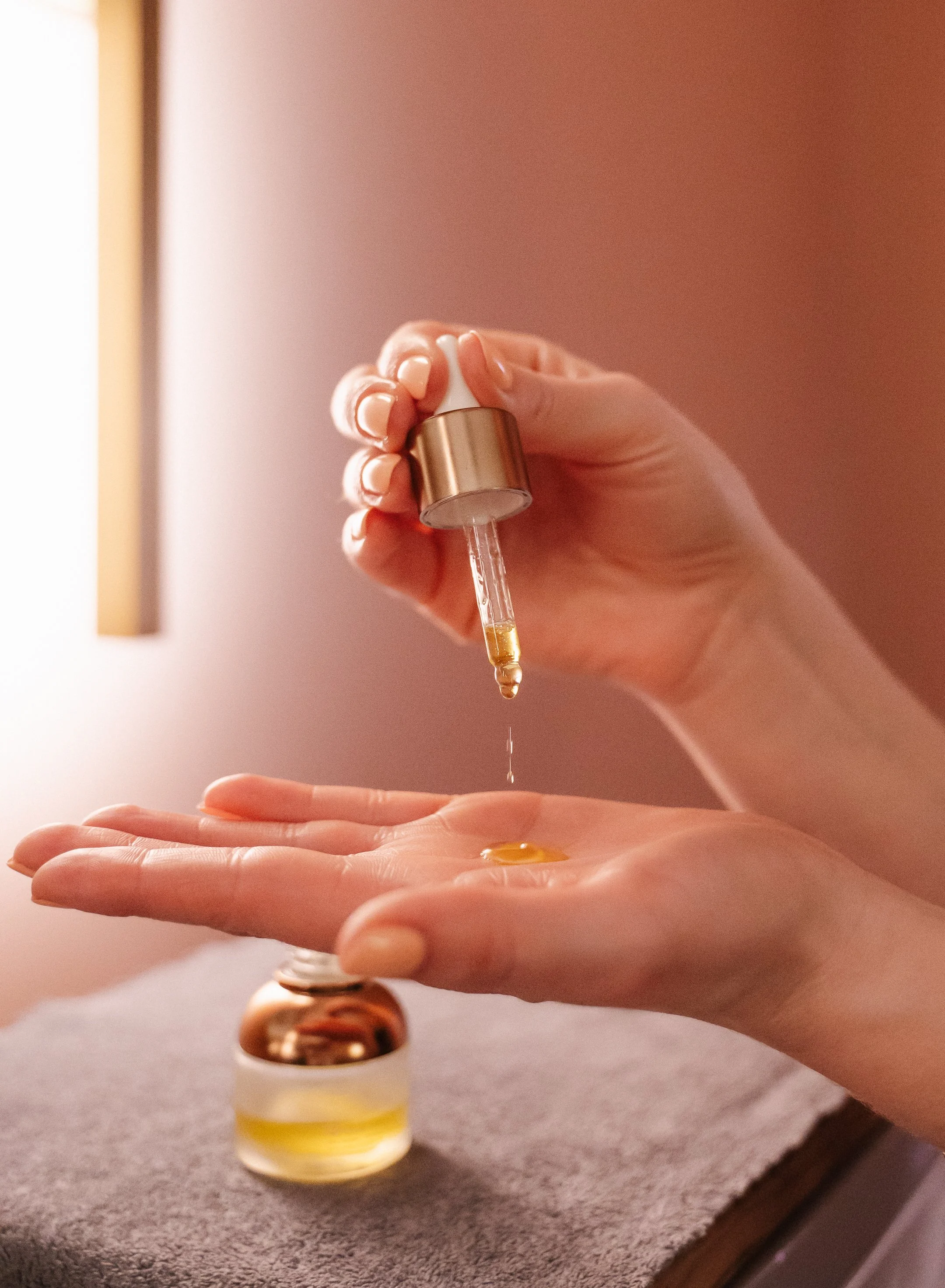 female hand squeezing drops of face serum into her palm