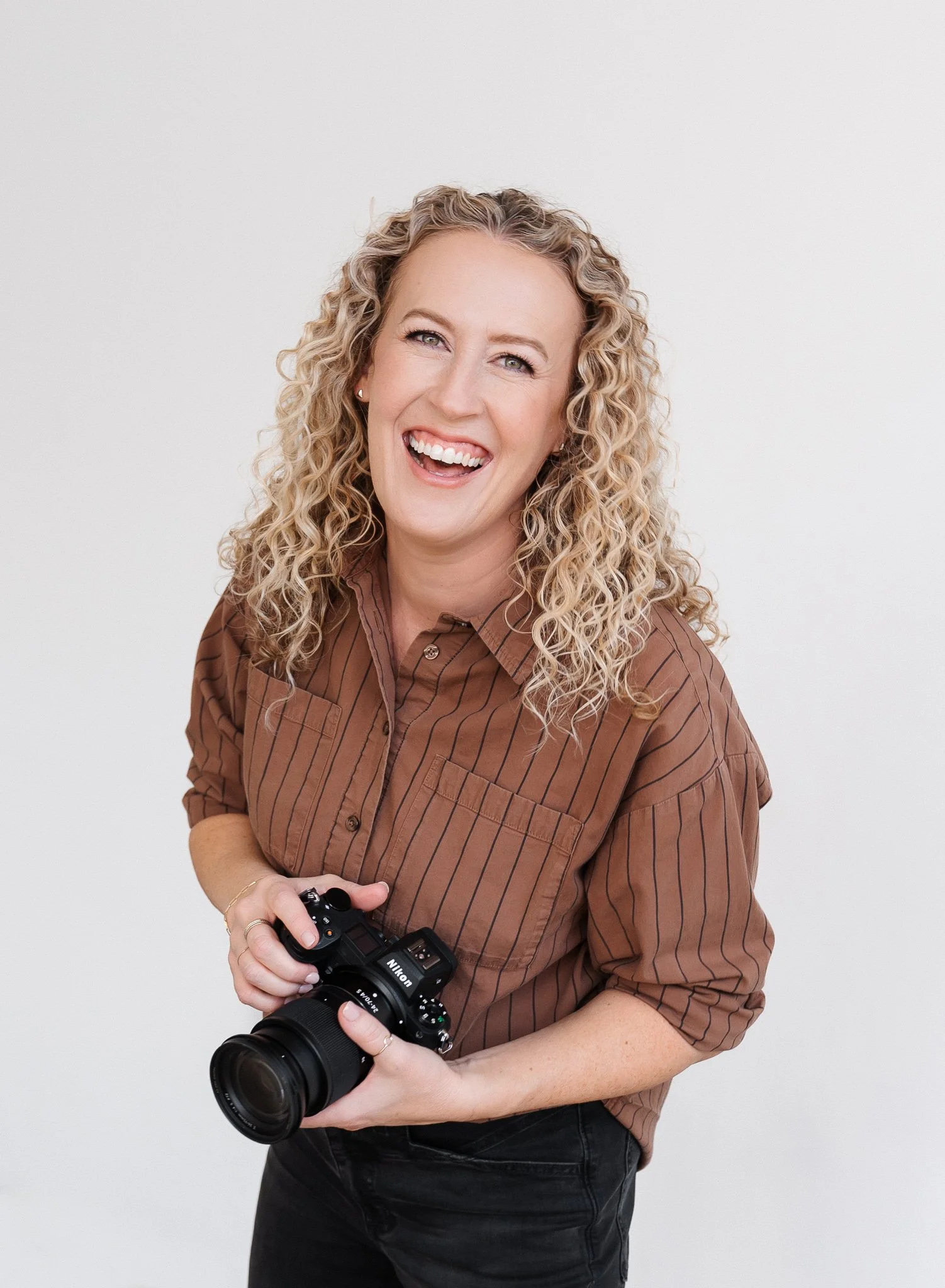 Jill Neil holding her camera and smiling