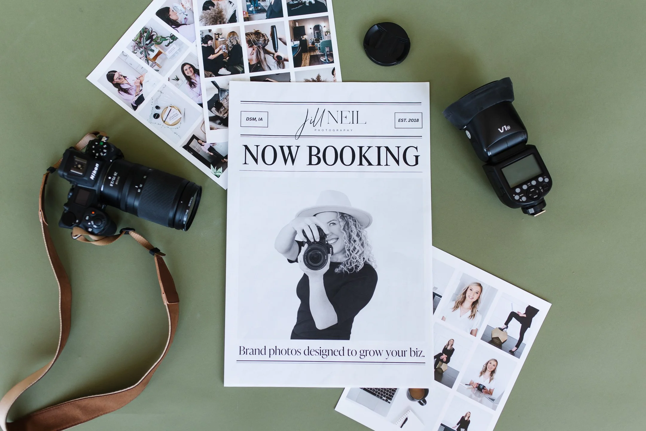 A flat lay of a newspaper mockup for Jill Neil Photography that says Now Booking layers on top of client photo collages next to camera and flash