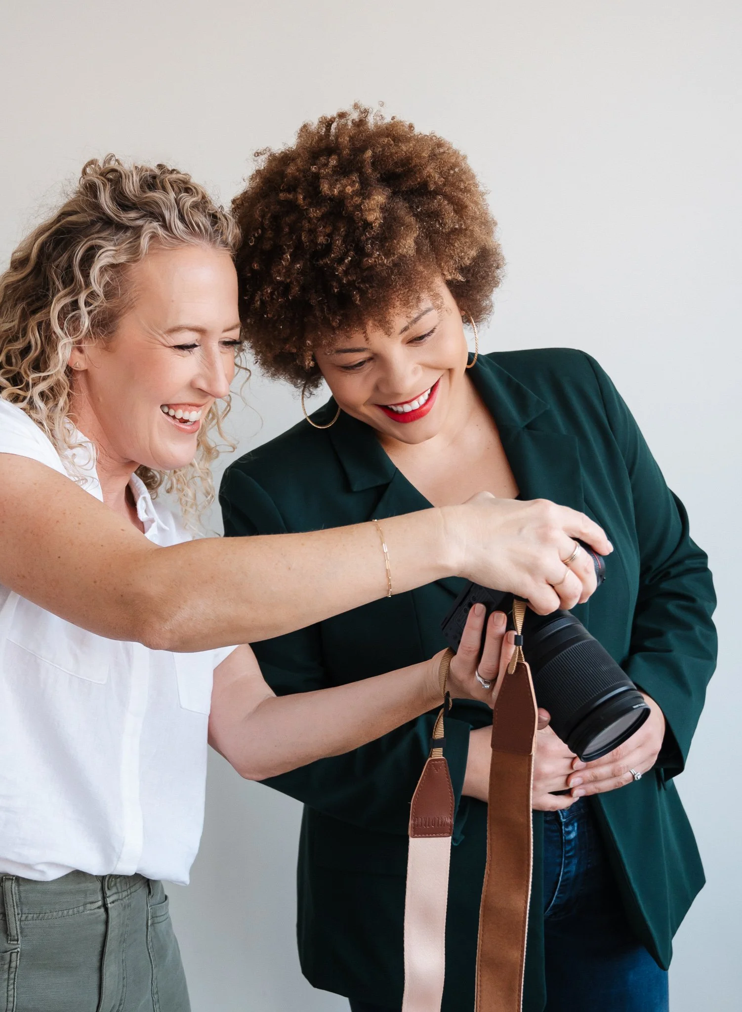 Jill showing her client images on the back of her camera as they both smile