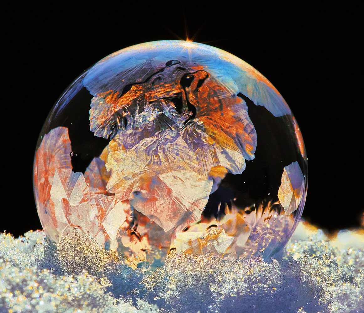 A close-up image of a colorful Ice Bubble, with ice crystals forming in winter in a moment of time and then it pops. Never to be recreated.