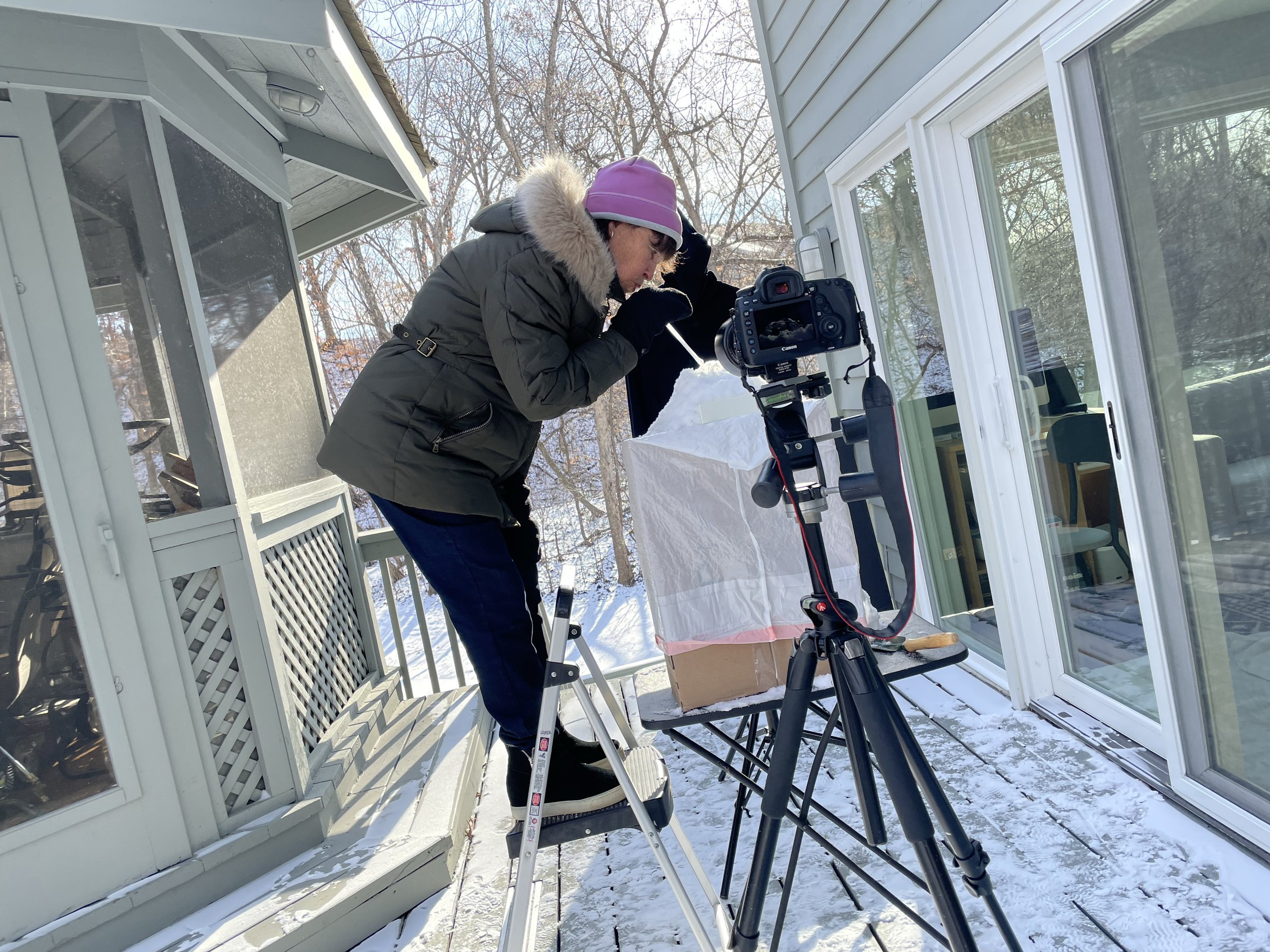 photo of a woman setting up a photography outside in the winter