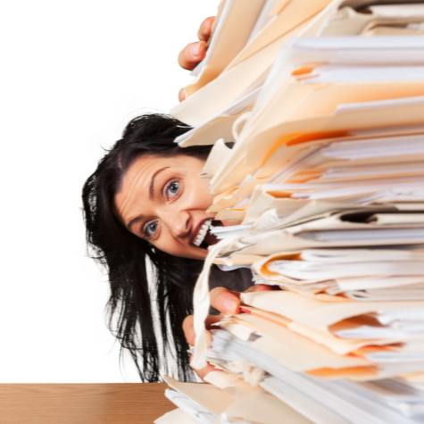 Woman overwhelmed with a large stack of papers at her desk