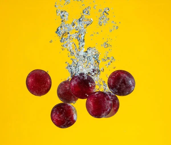 Red grapes on yellow background.